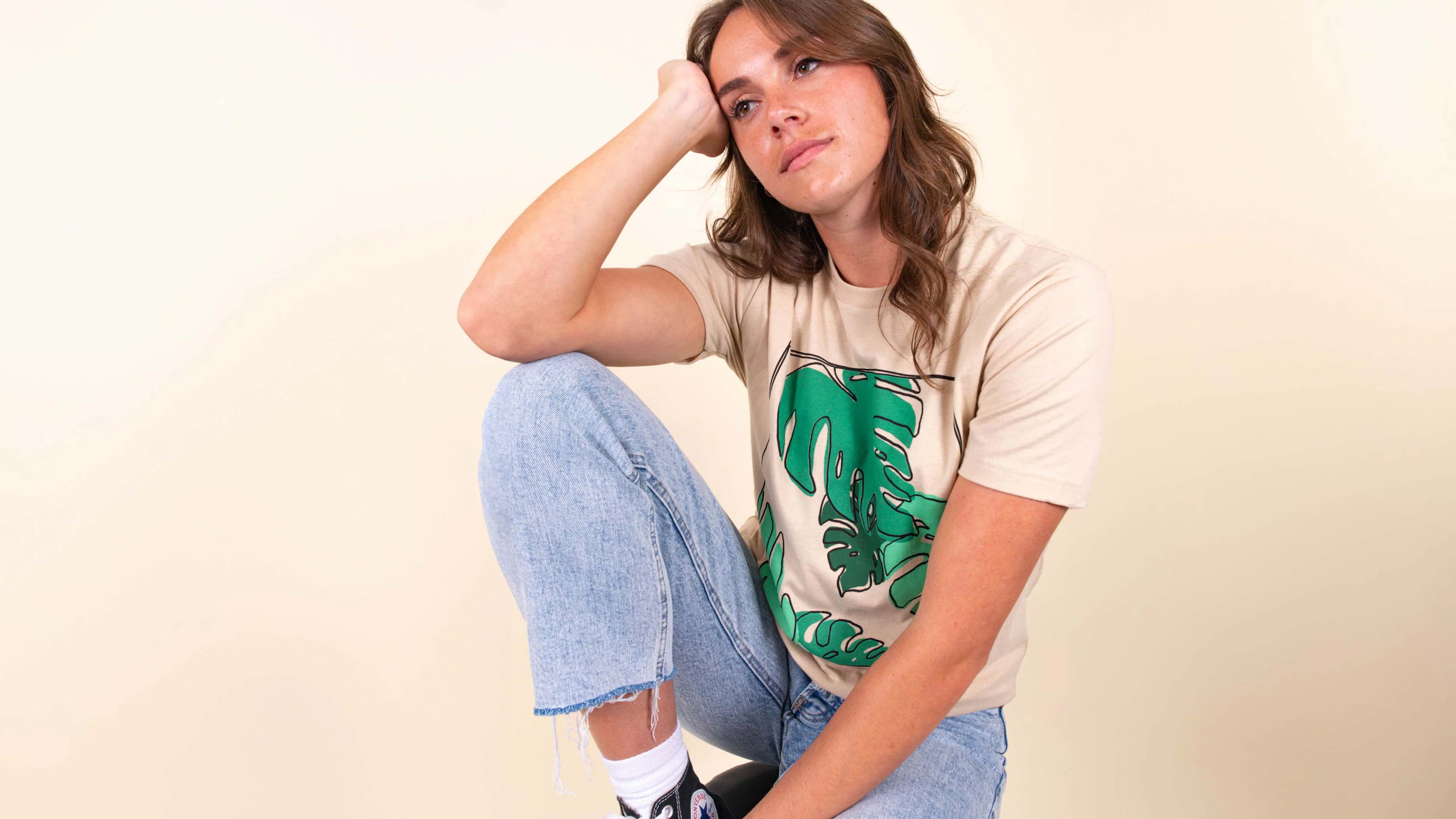 women kneeling wearing a tan t-shirt