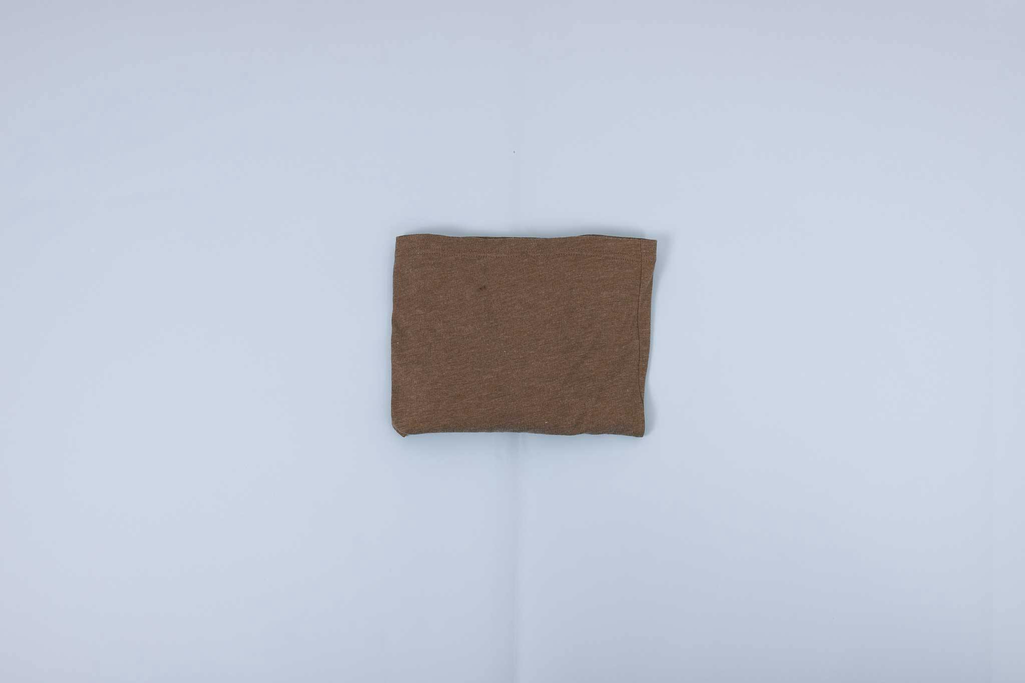 Olive long sleeve shirt folded into a rectangle on a light blue background Olive long sleeve shirt folded into a rectangle on a light blue background