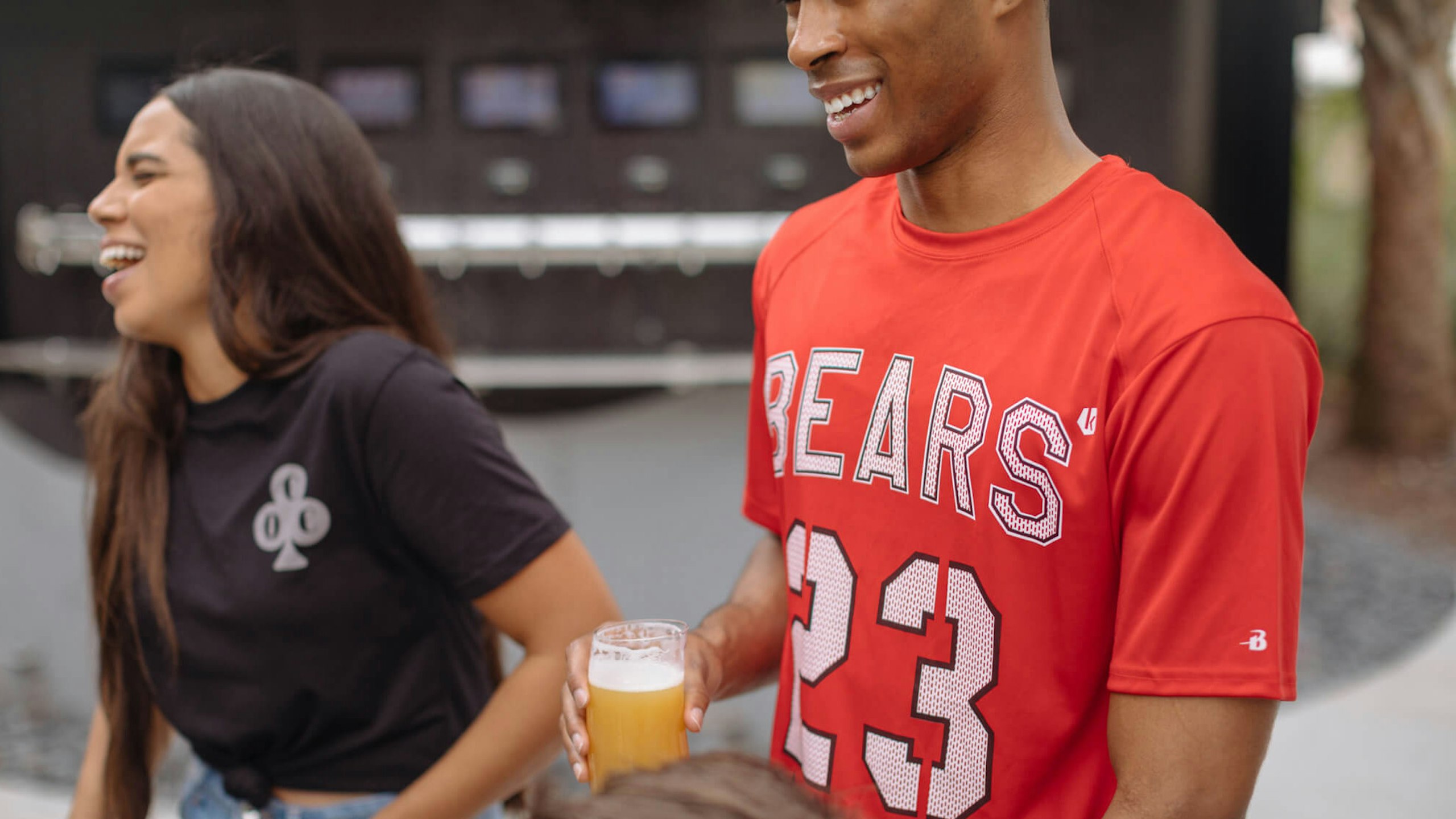 women in a black t-shirt laughing and a man in a red shirt smiling