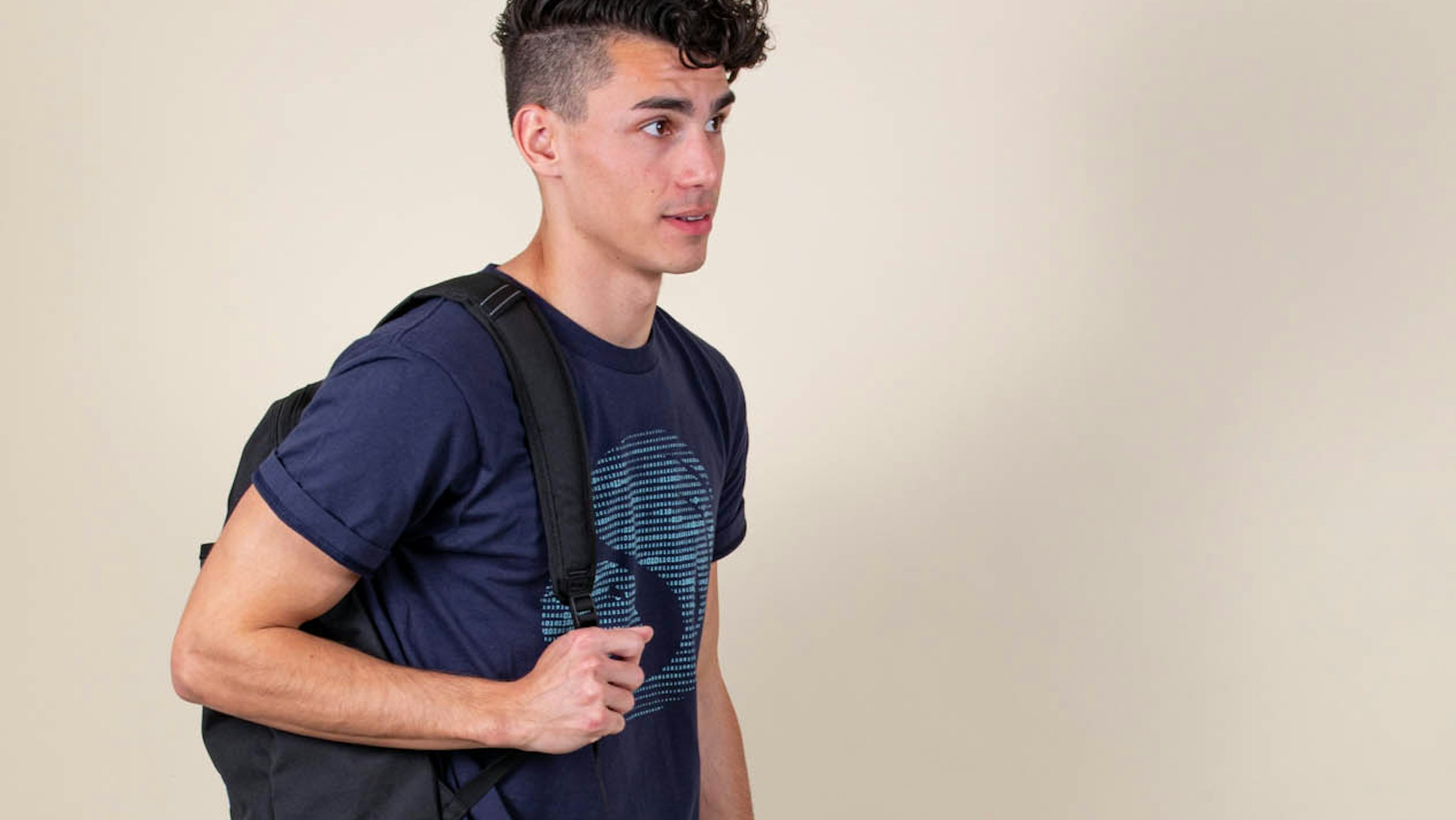 man wearing a navy t-shirt with a black pack