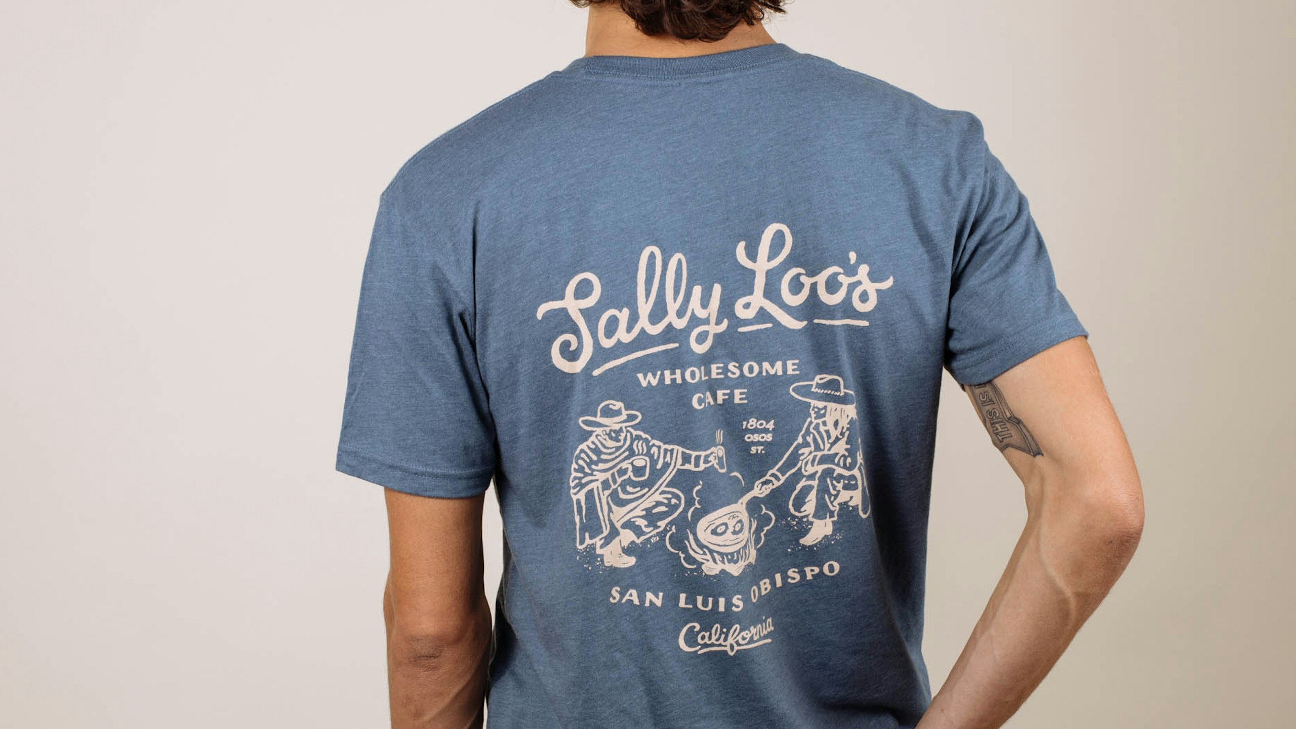 man wearing a blue t-shirt with a camping scene printed on it
