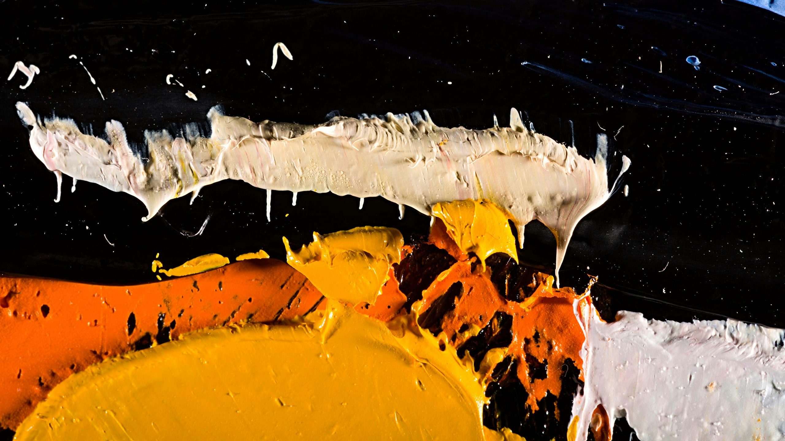yellow, orange, and white paint on a black board