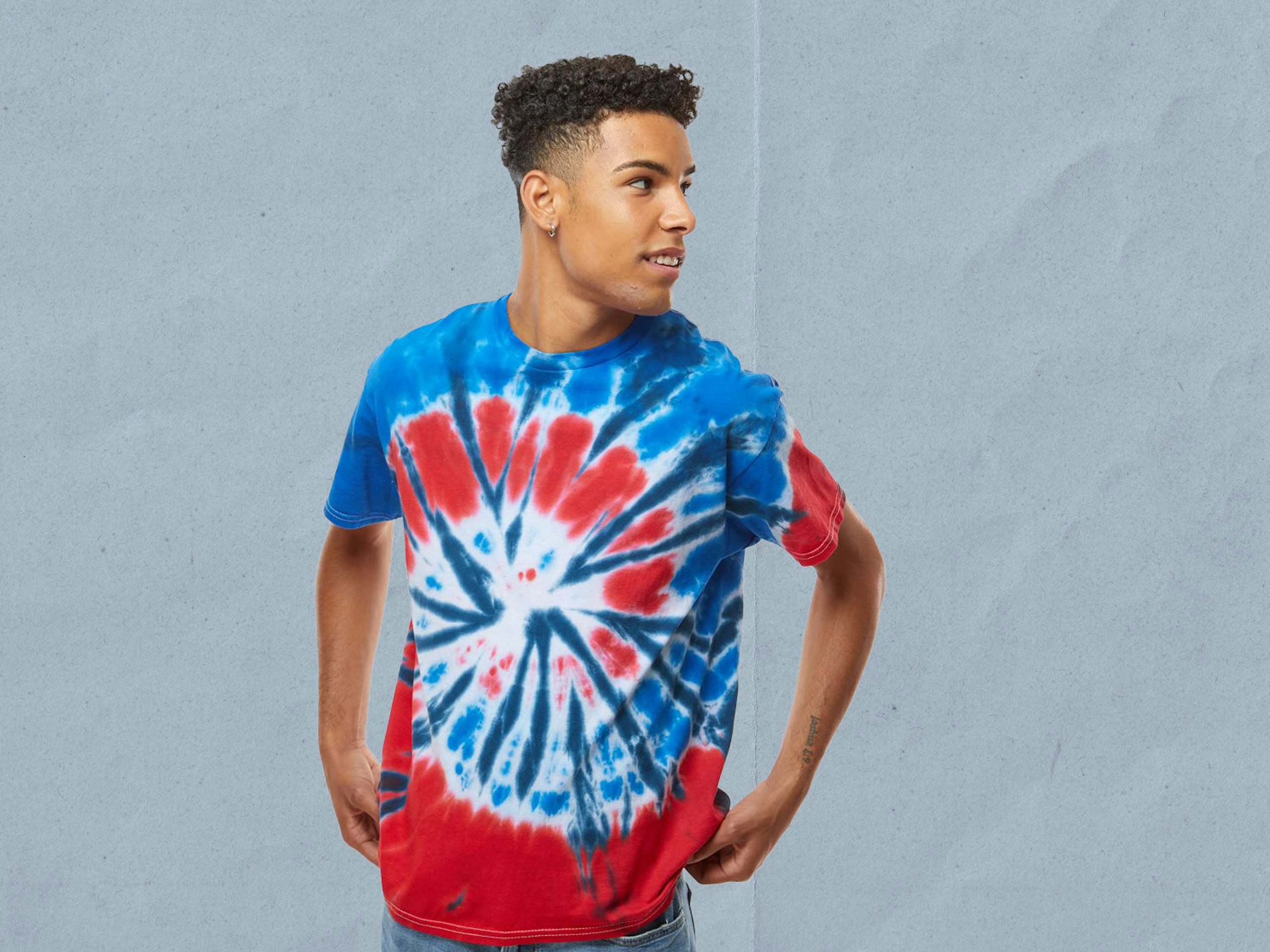 a man wearing a blue and red tie-dyed t-shirt in front of a blue background
