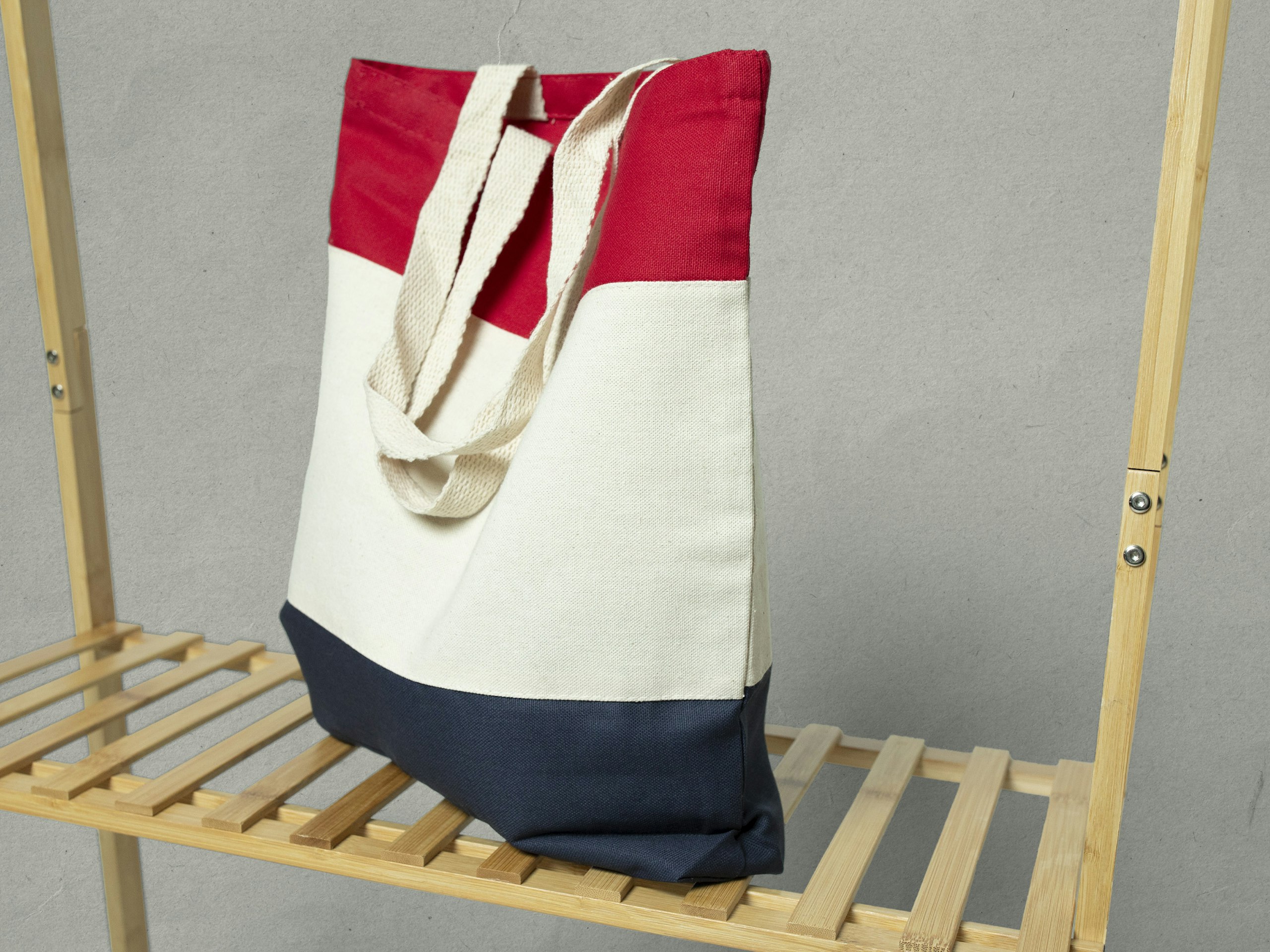 blue natural and red tote bag on a wood shelf