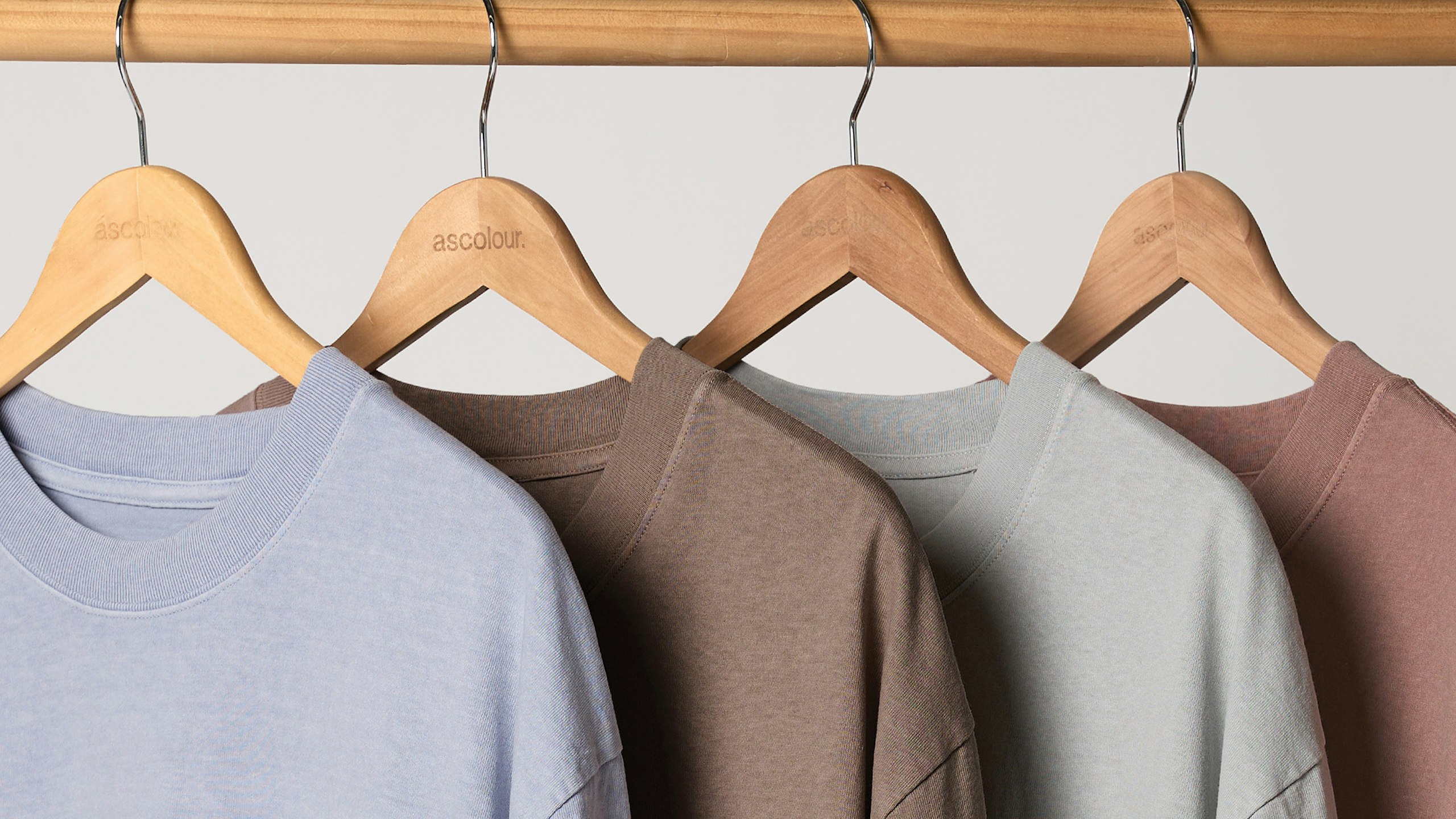 four heavyweight t-shirts hanging on a wooden hangers