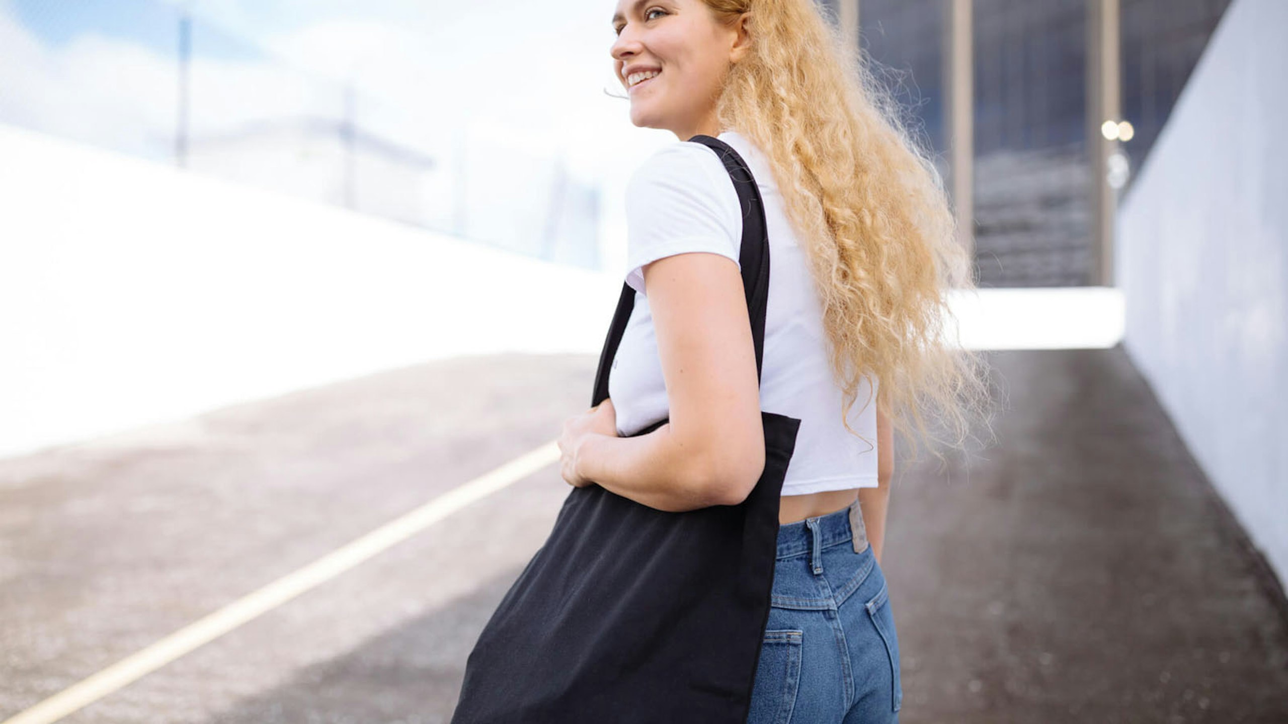 girl holding a black tote bag