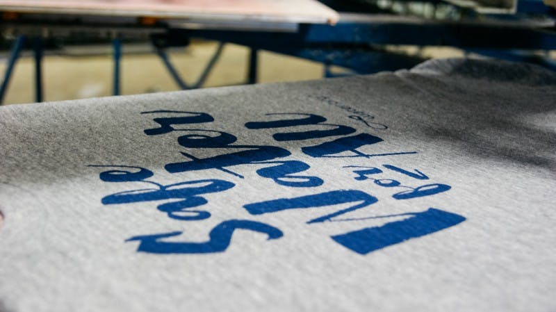 close up of a gray shirt getting a blue design printed on it