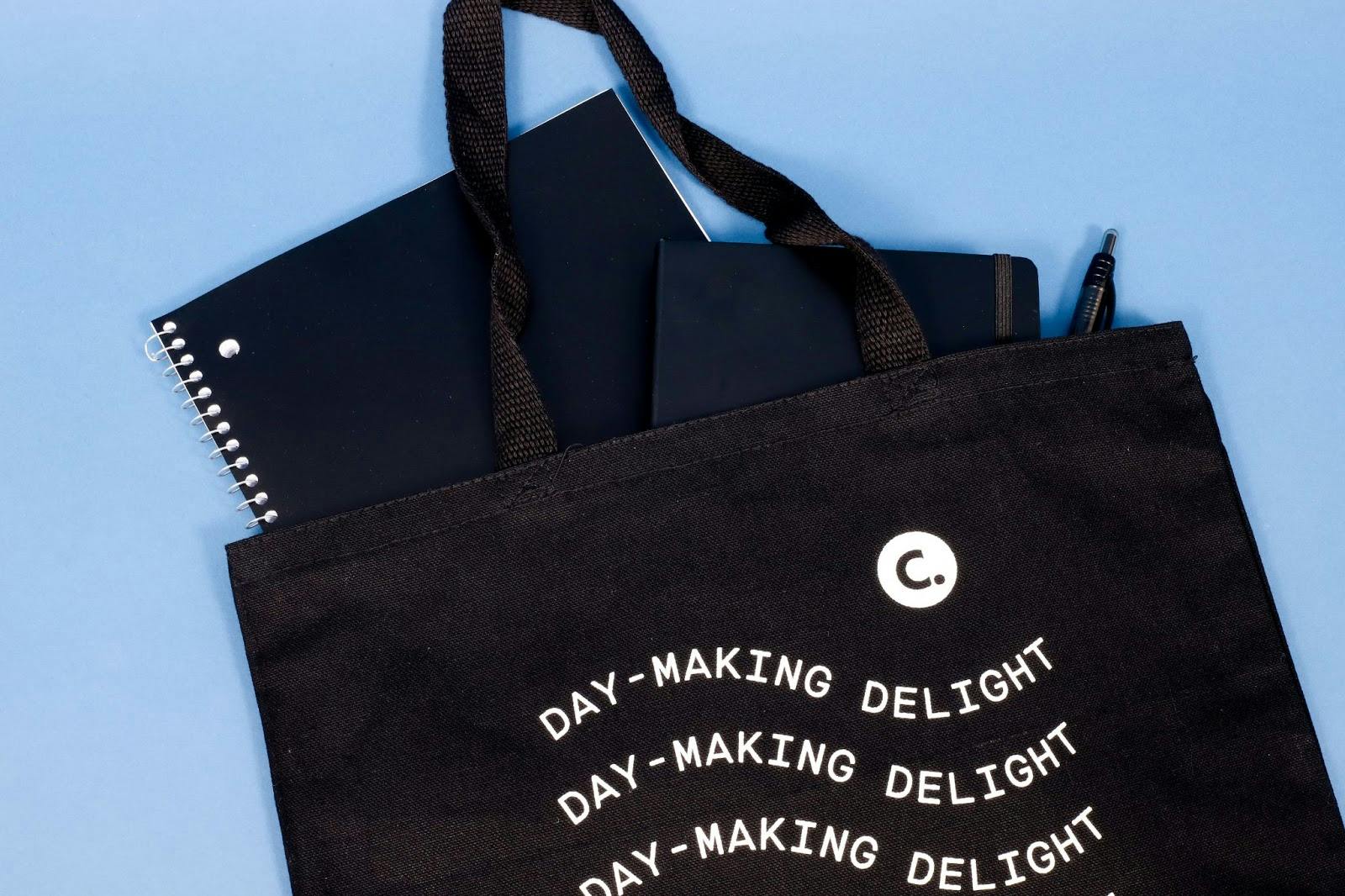 black tote with a spiral notebook, journal and pen sticking out black tote with a spiral notebook, journal and pen sticking out