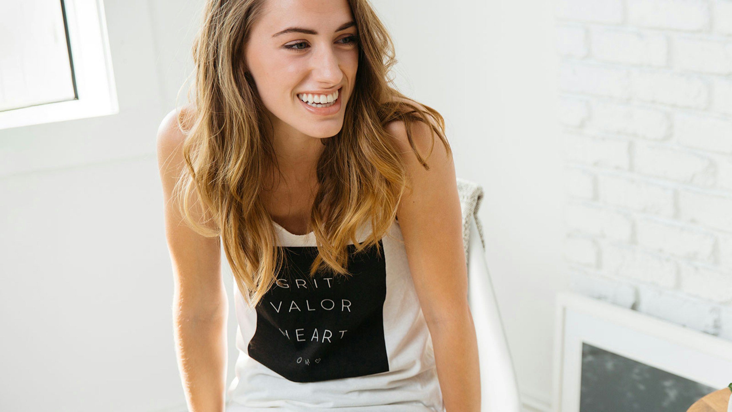 women wearing a white sleeveless shirt with a large black design on the front