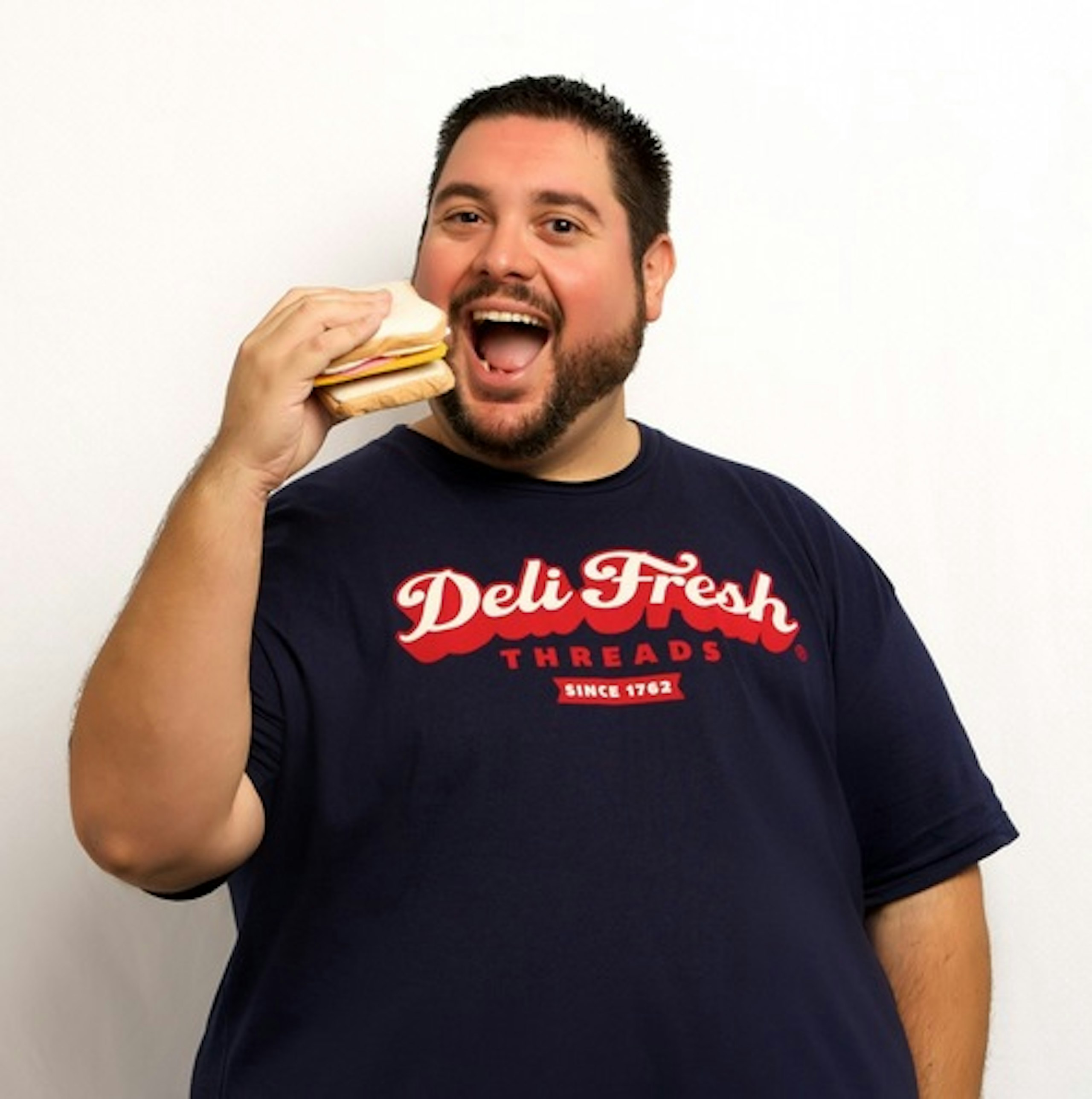 guy with deli fresh t-shirt holding a sandwich