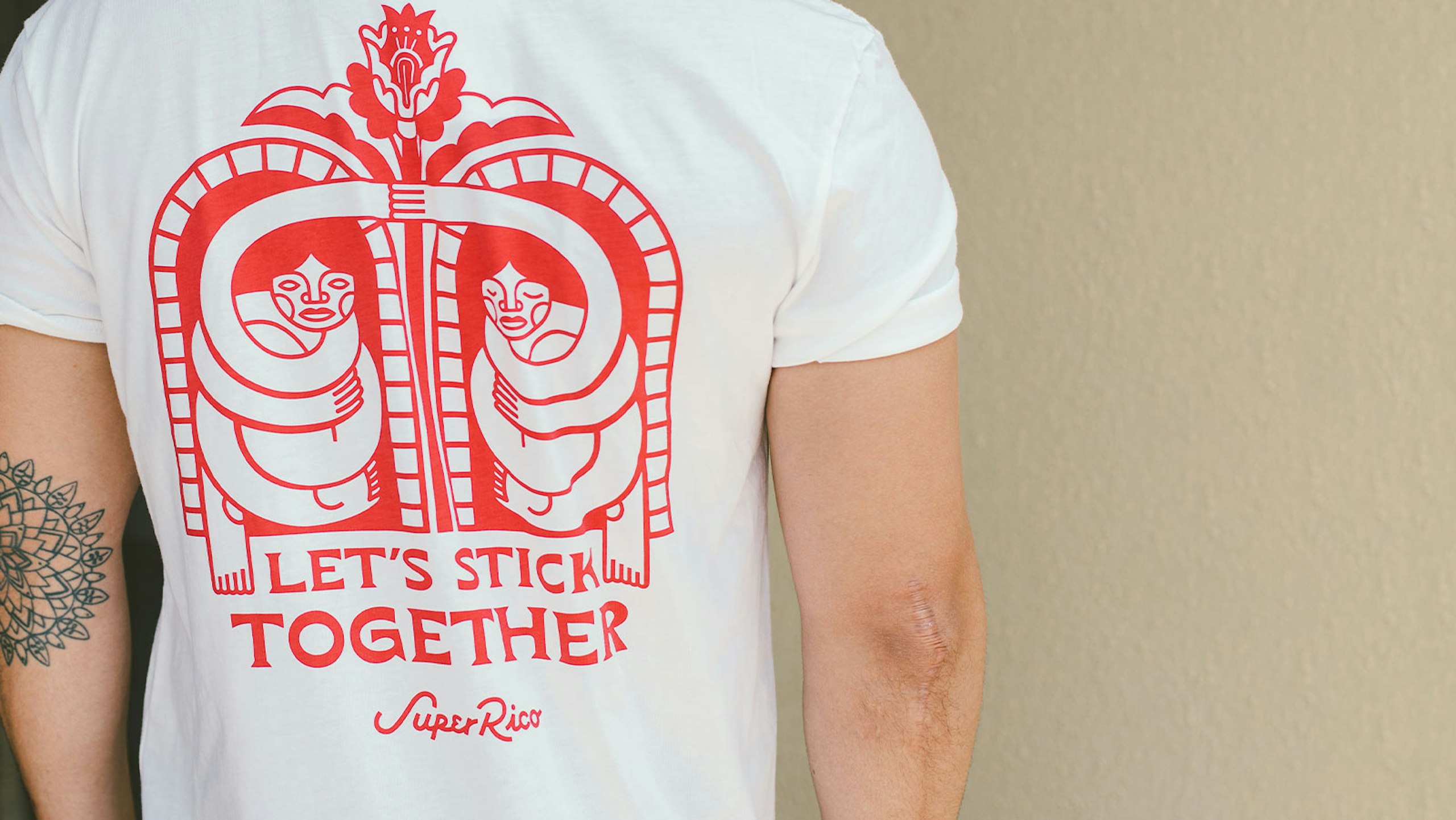 back of a man wearing a white shirt with red imprint design