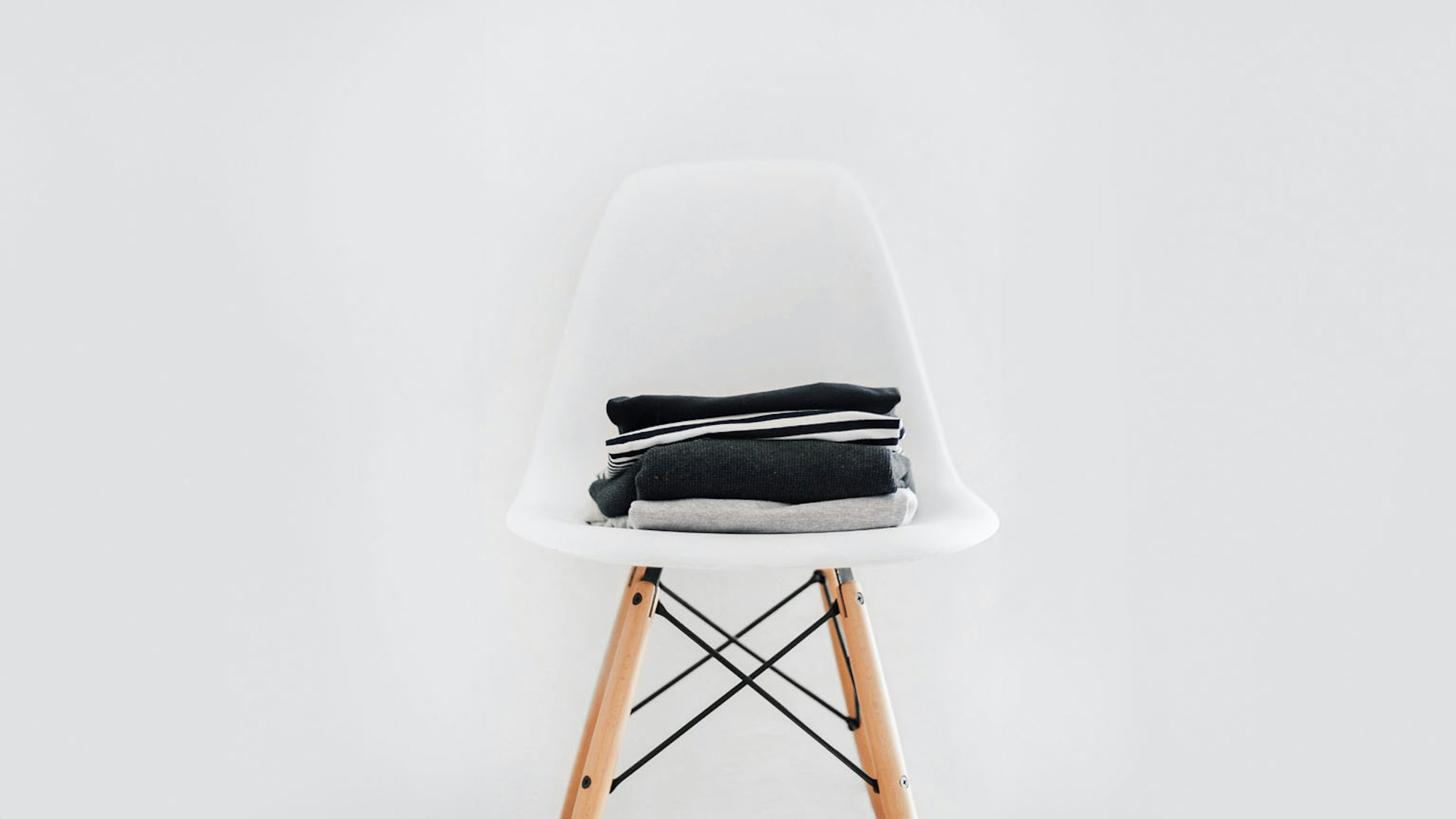 white chair with a small stack of folded shirts