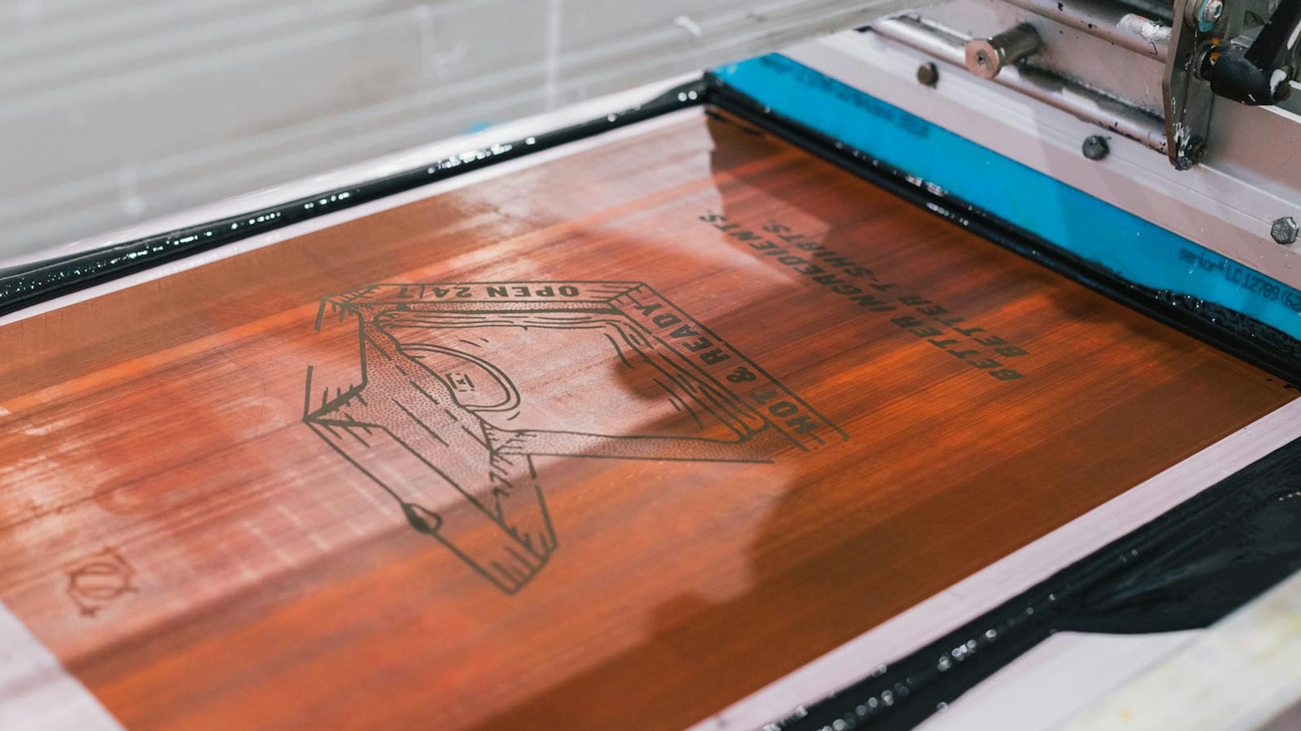 close up view of a screen printer with black ink on the screen