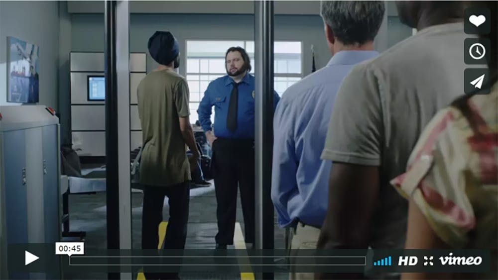 Screenshot of a video showing an Indian person wearing a dastar and talking to airport security personel.