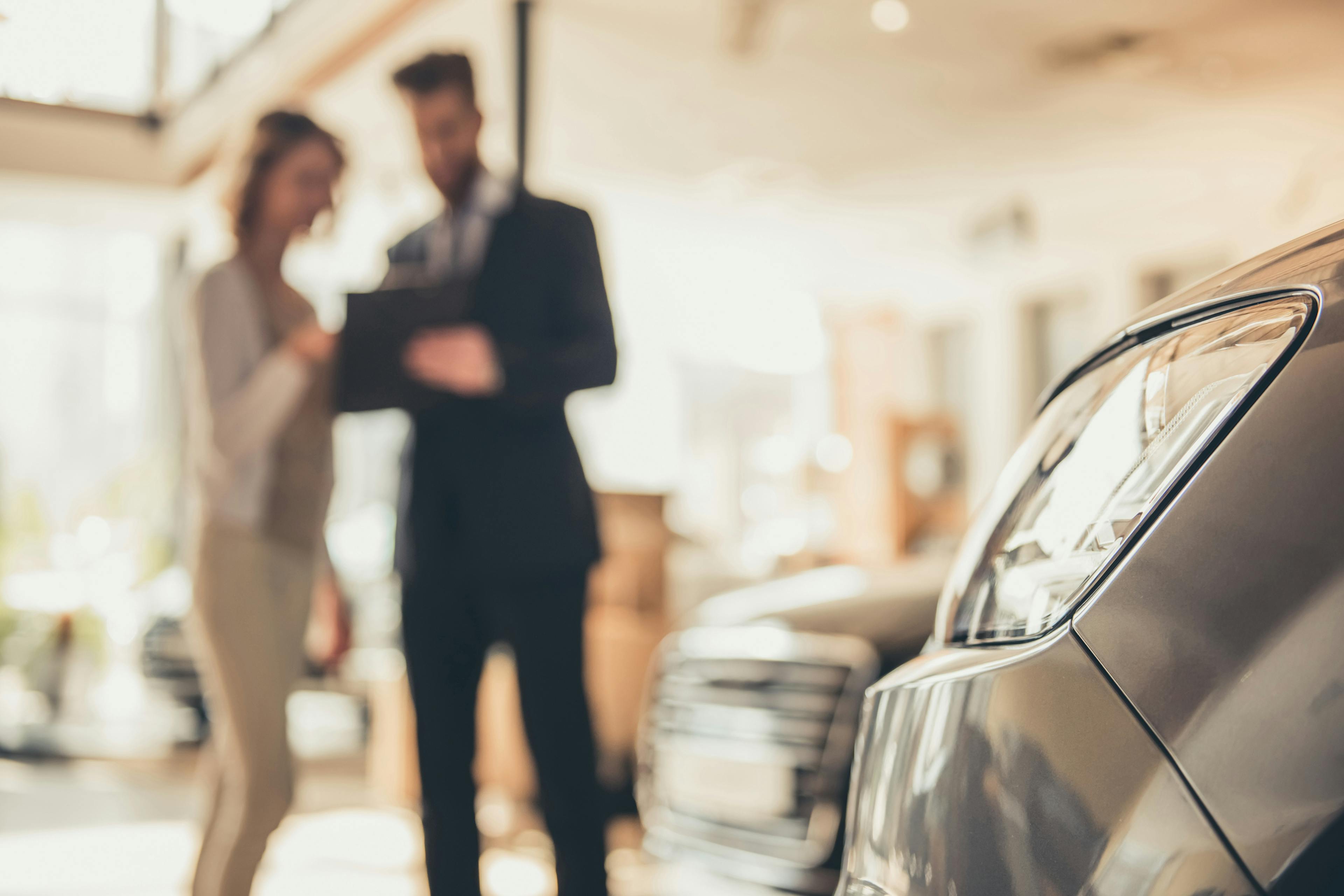 a man and a woman are discussing something about a car