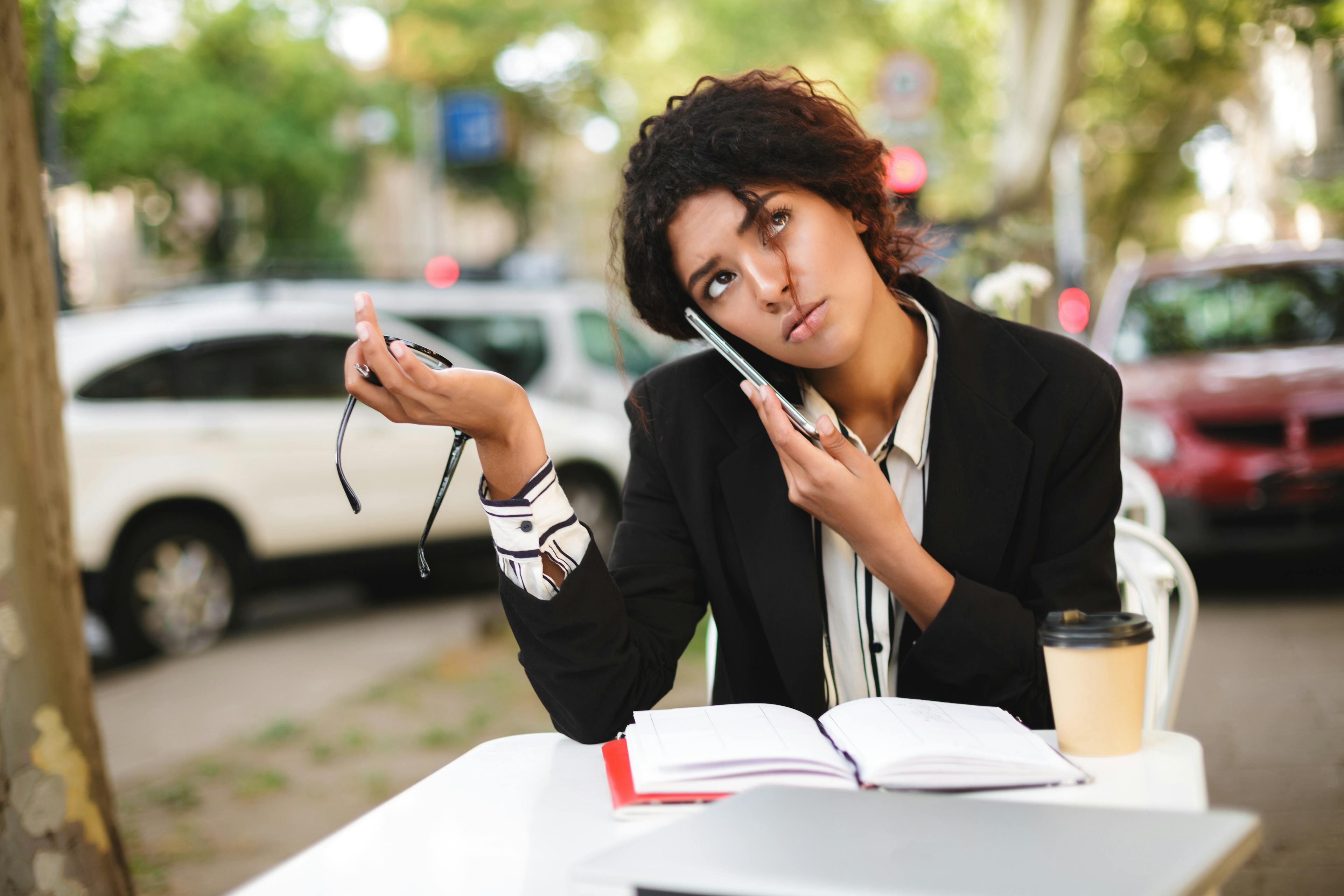 Questioning woman on phone, holding glasses