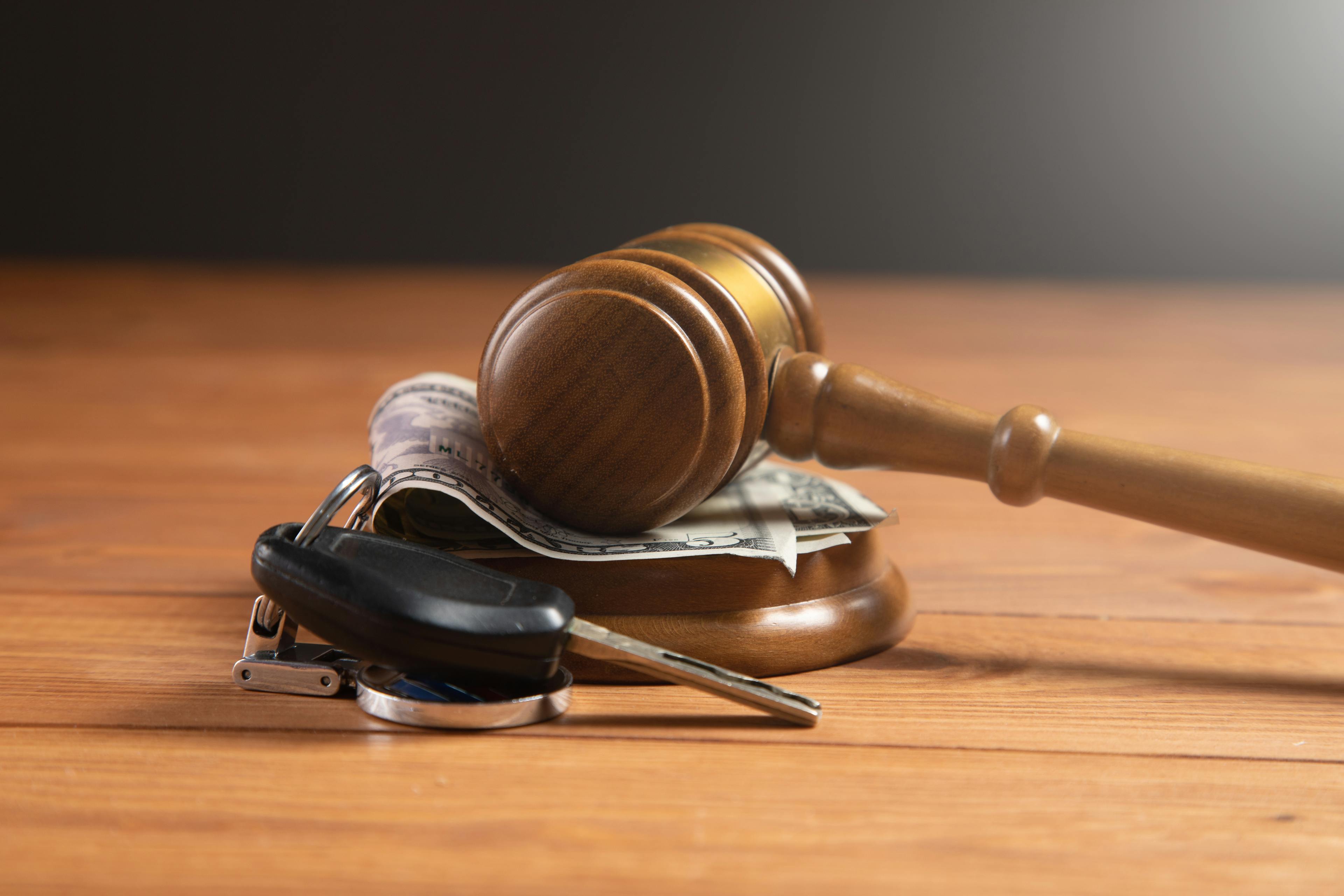 court gavel with money and car keys on a table