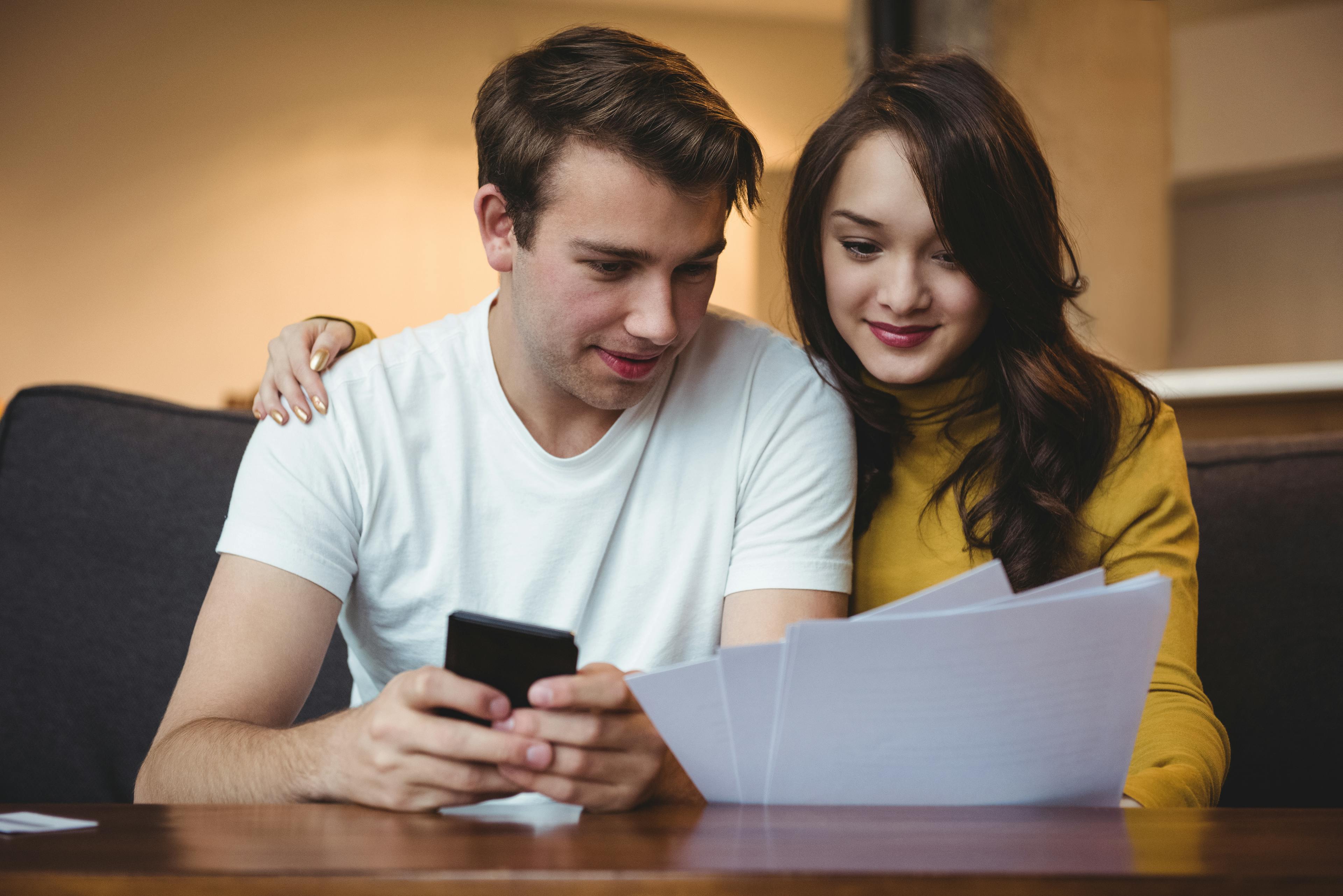 couple discussing with financial documents calculator living room