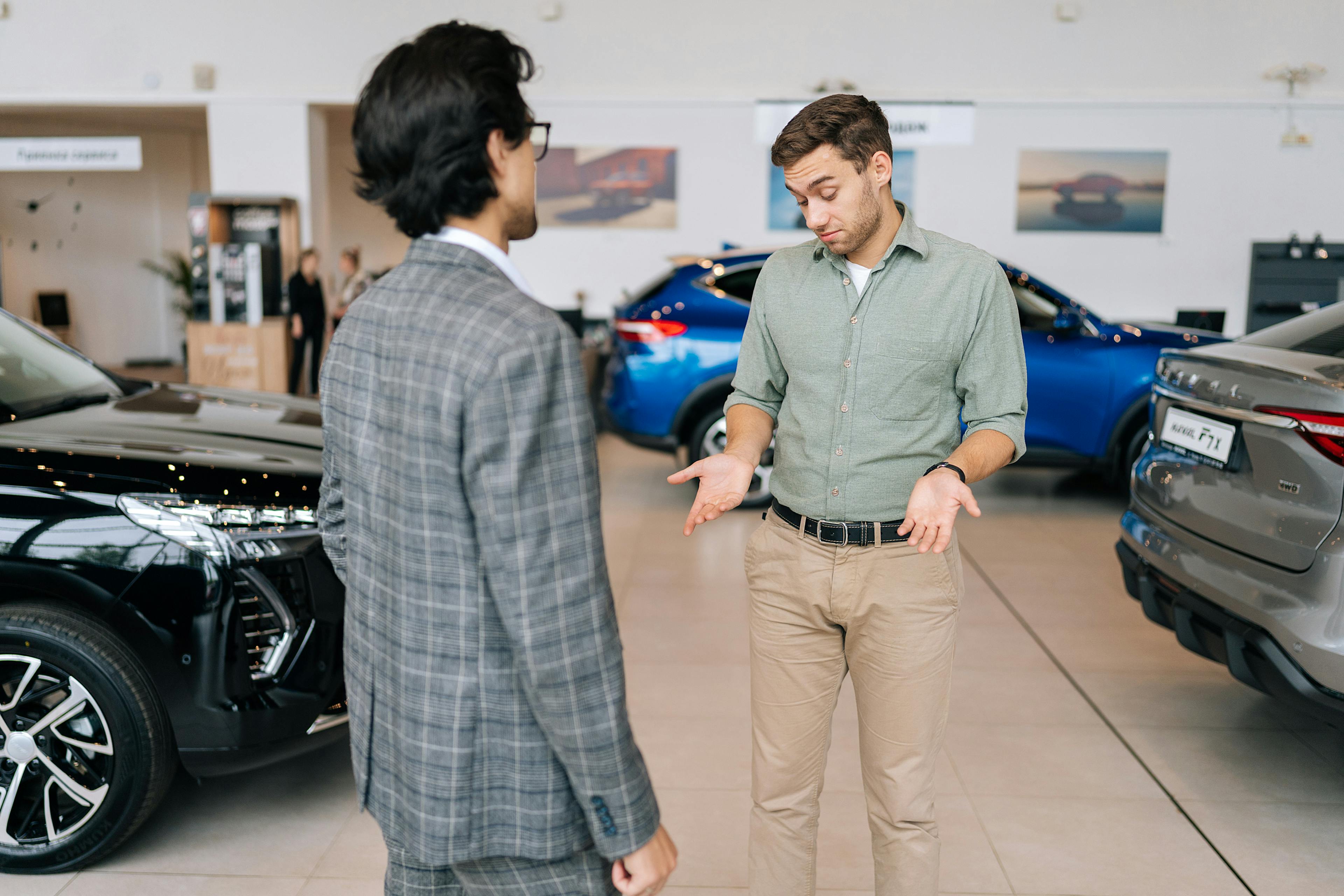 a car salesperson discussing PCP vs. HP car finance in showroom to a customer