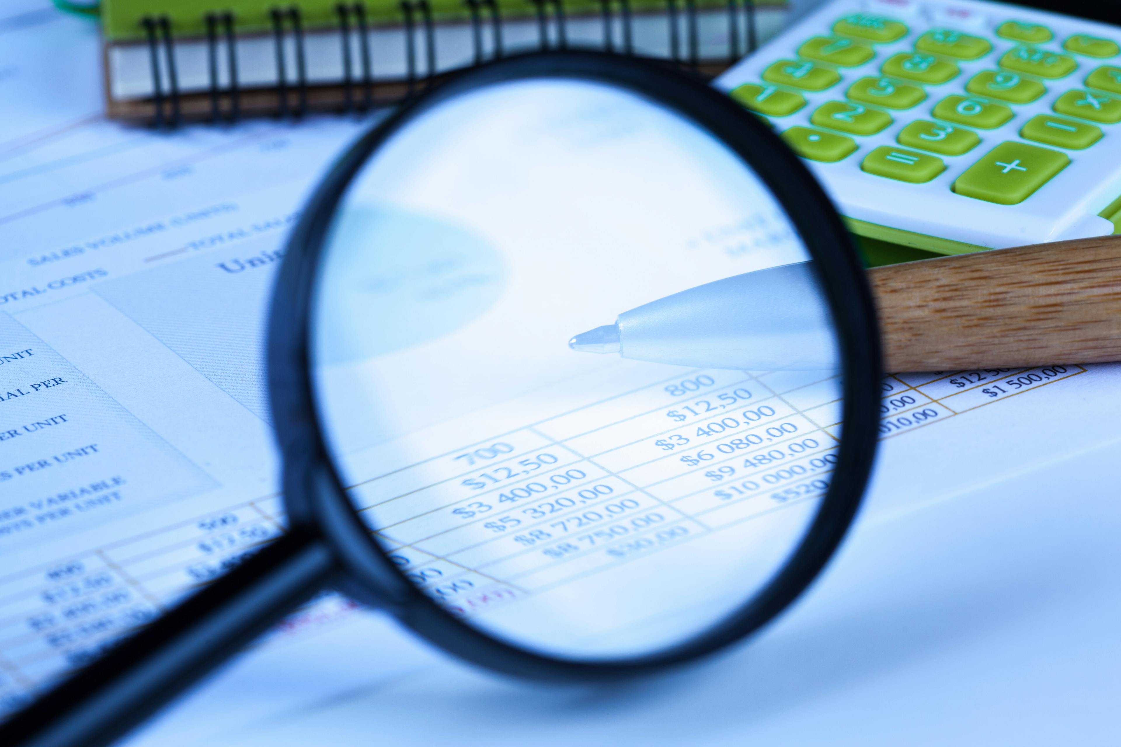 financial documents with a magnifying glass
