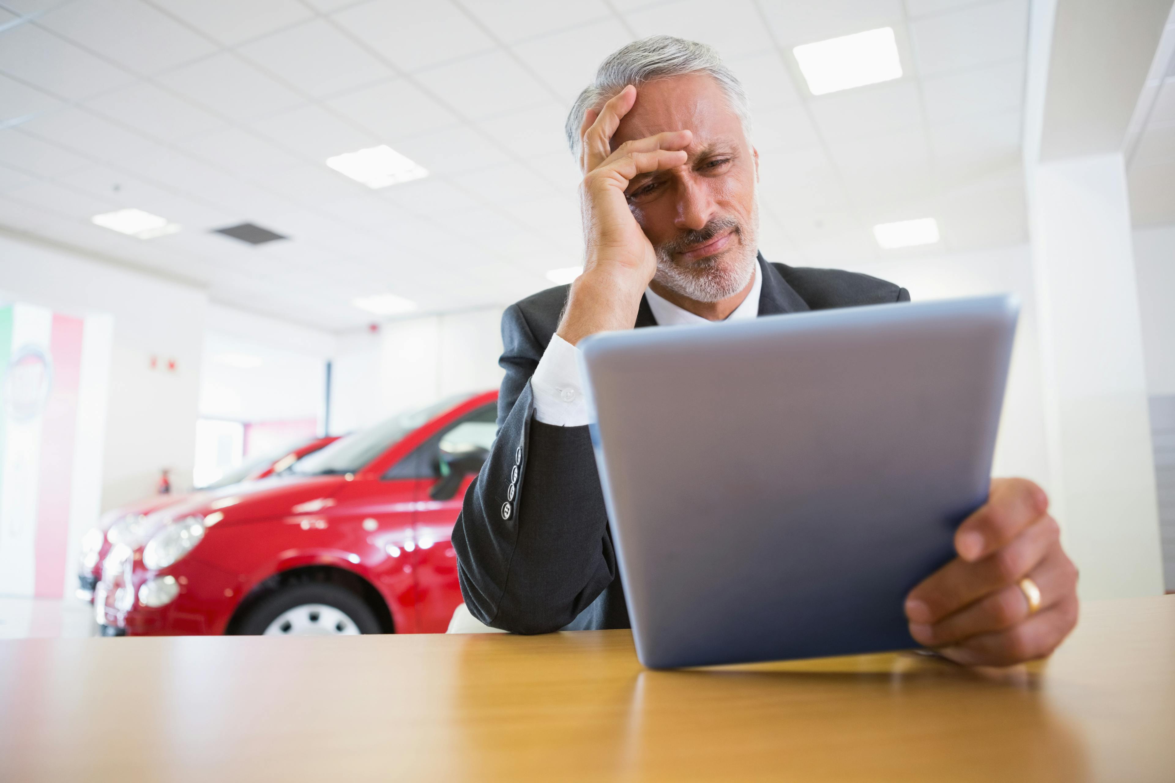 Stressed MotoNovo Finance officer using tablet device