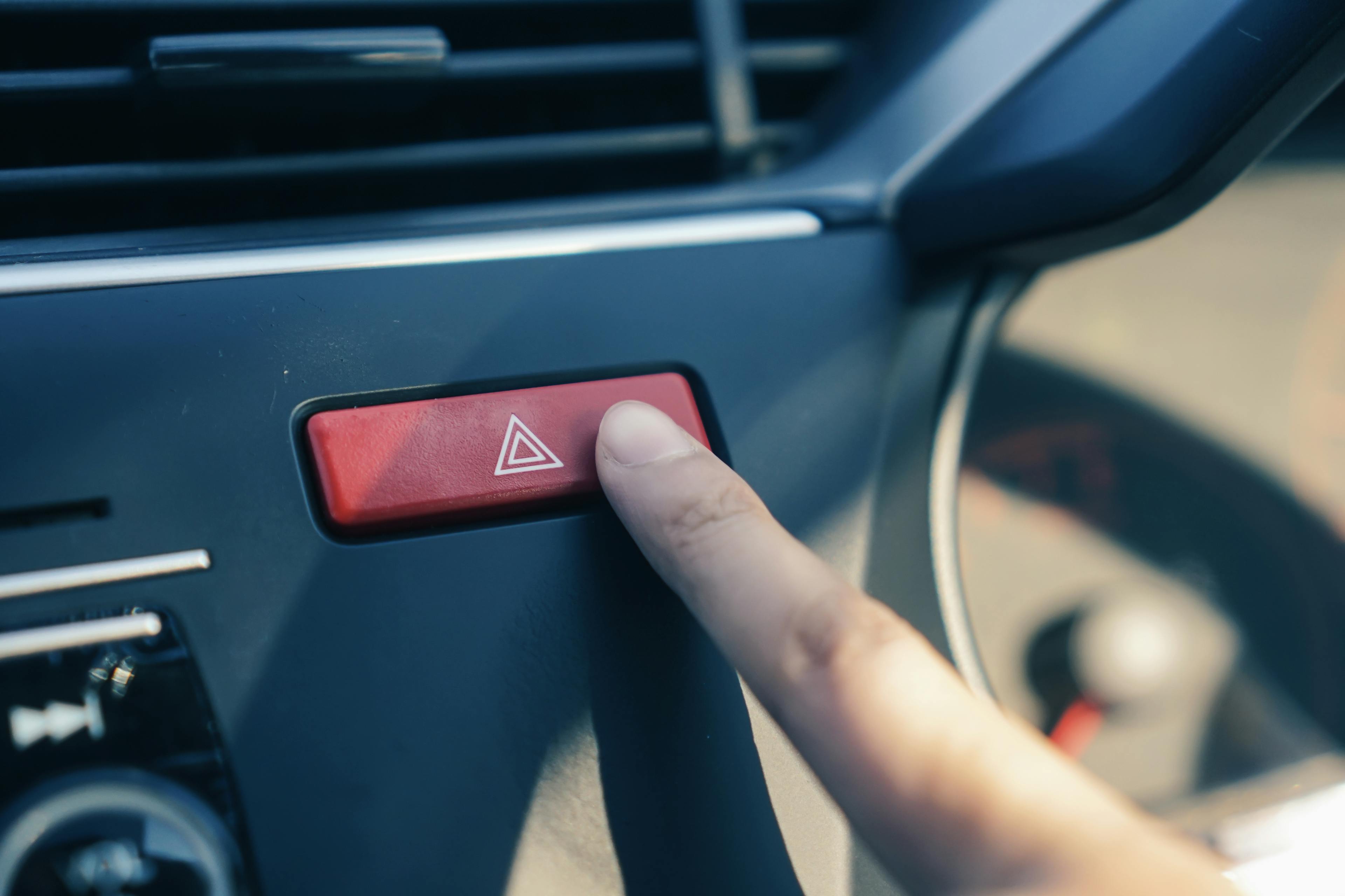 Finger pressing car's hazard warning button