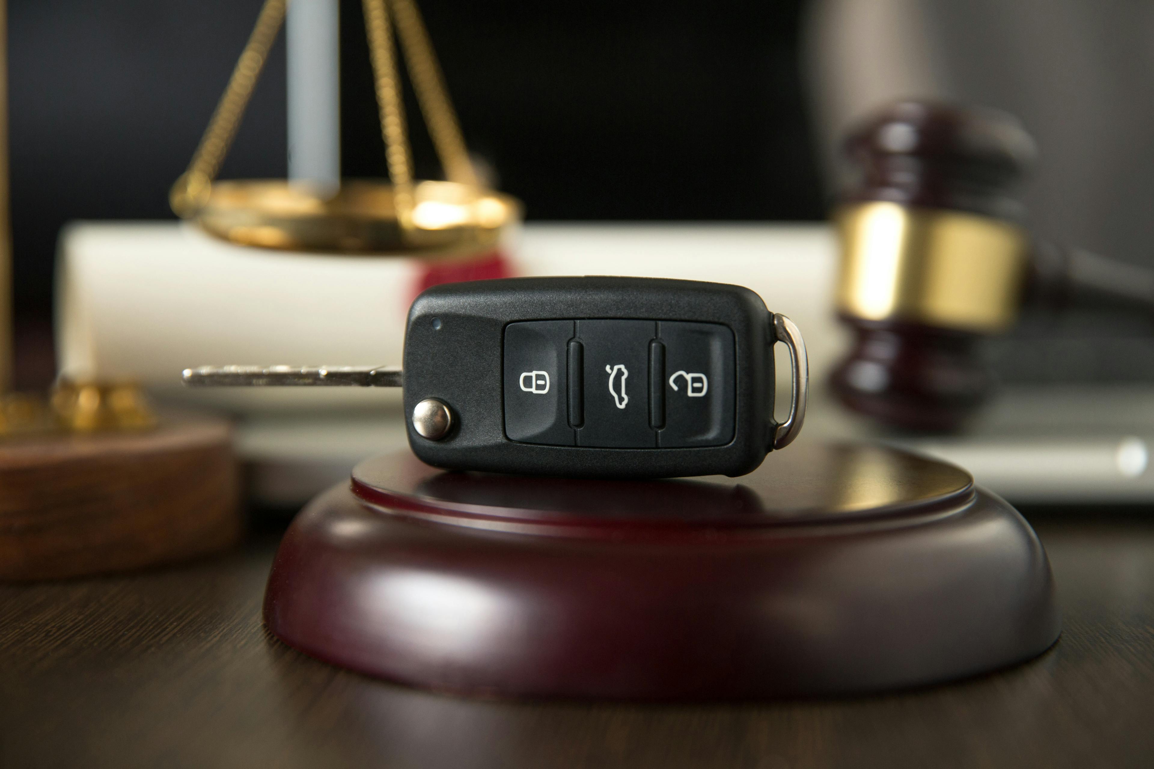 Car key on gavel with justice scales