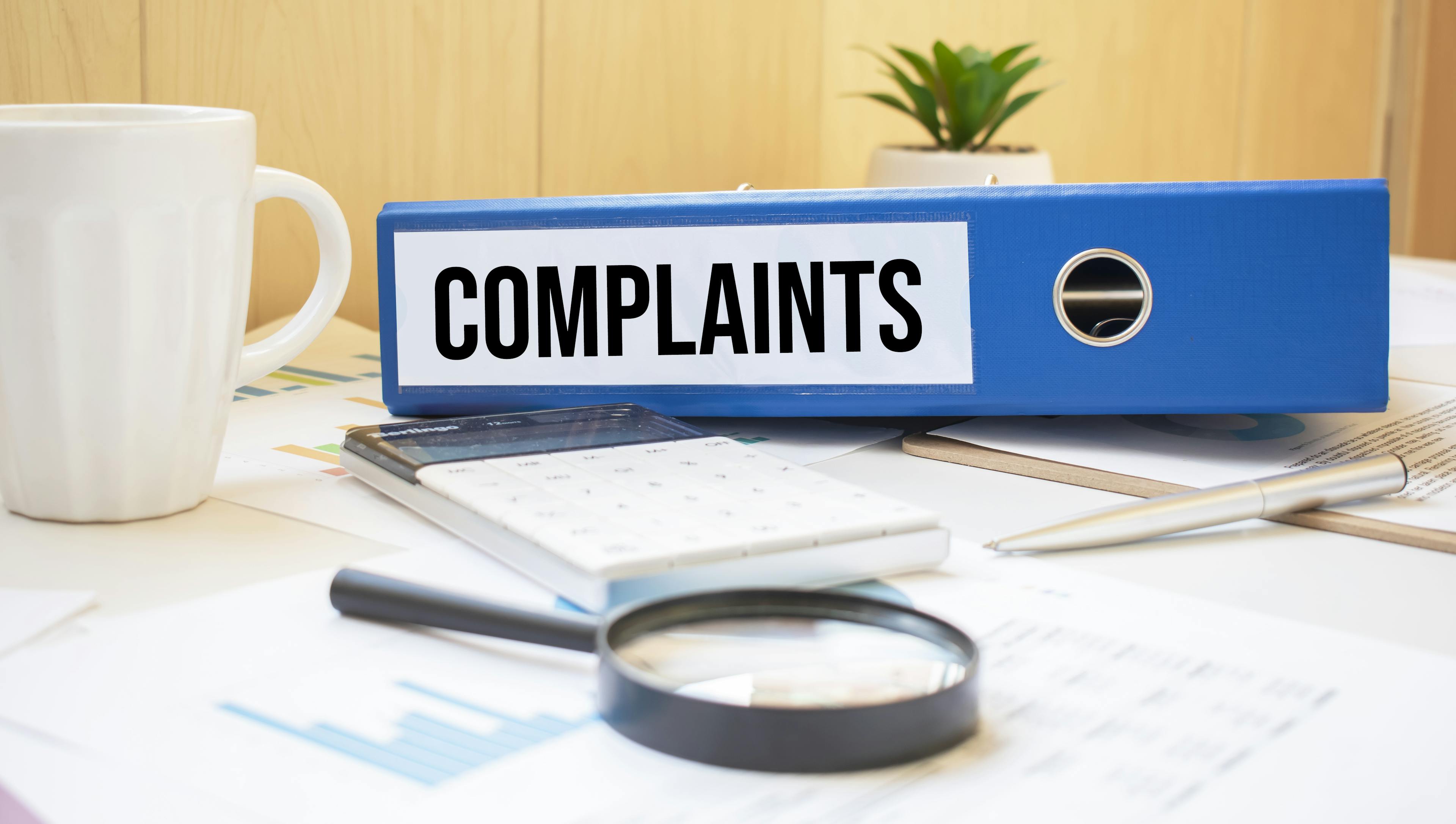 Complaints binder with documents and magnifier