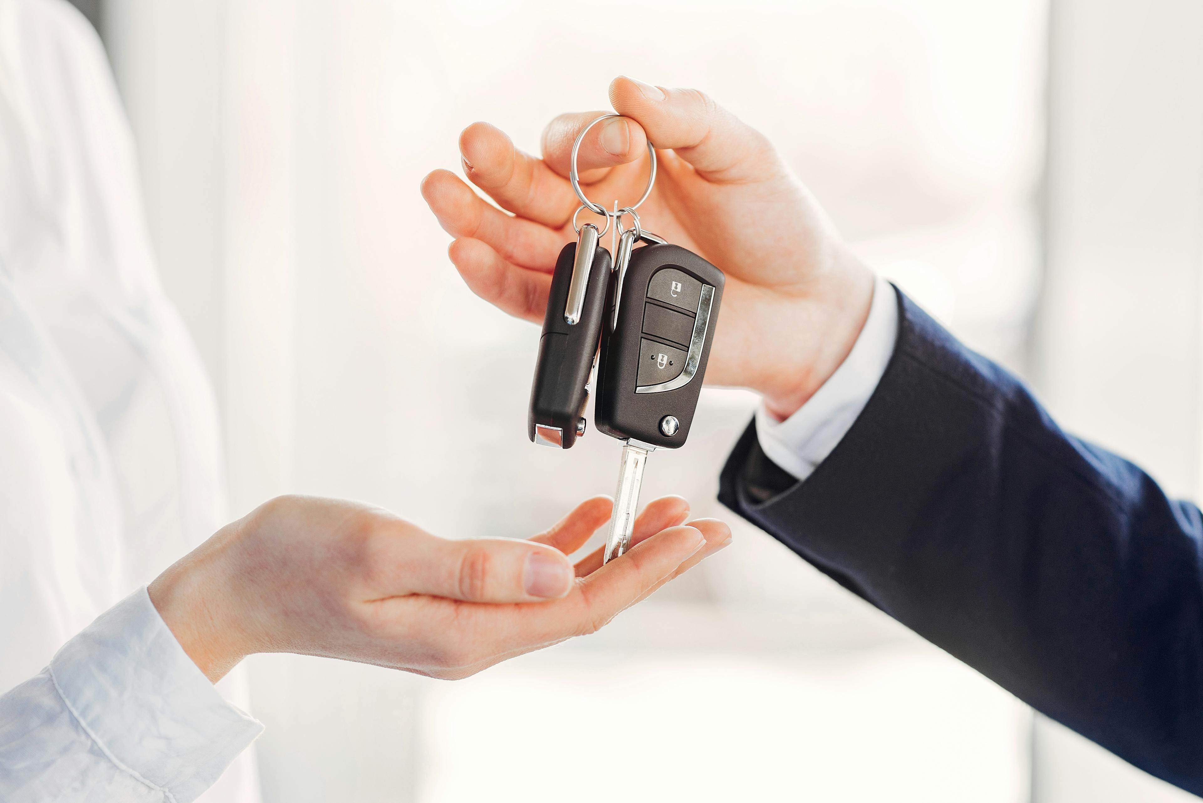 car keys being handed down from a sales person to a customer