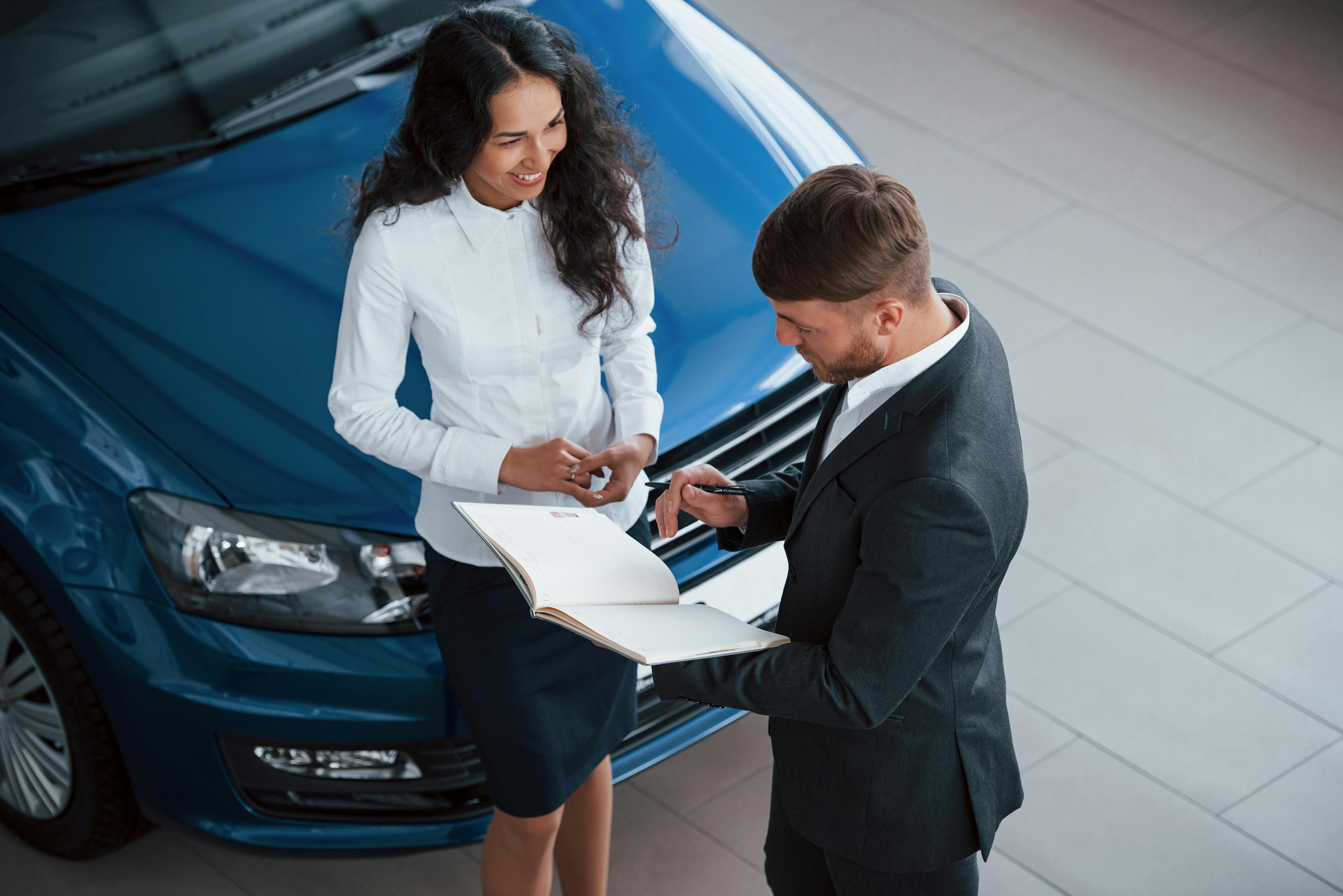 woman talking to a car saleman in a dealership