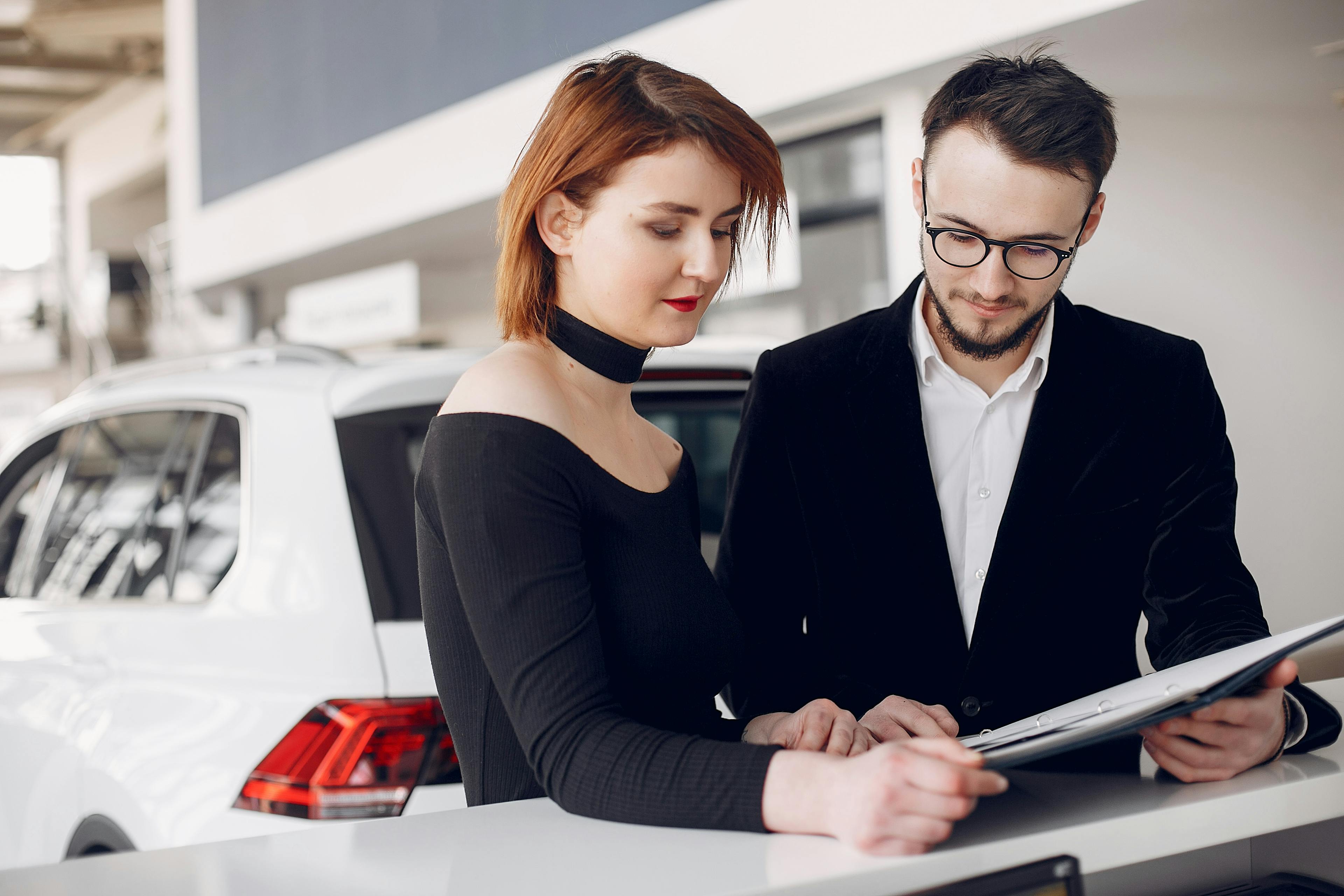 couple reviewing car finance documents in a dealership