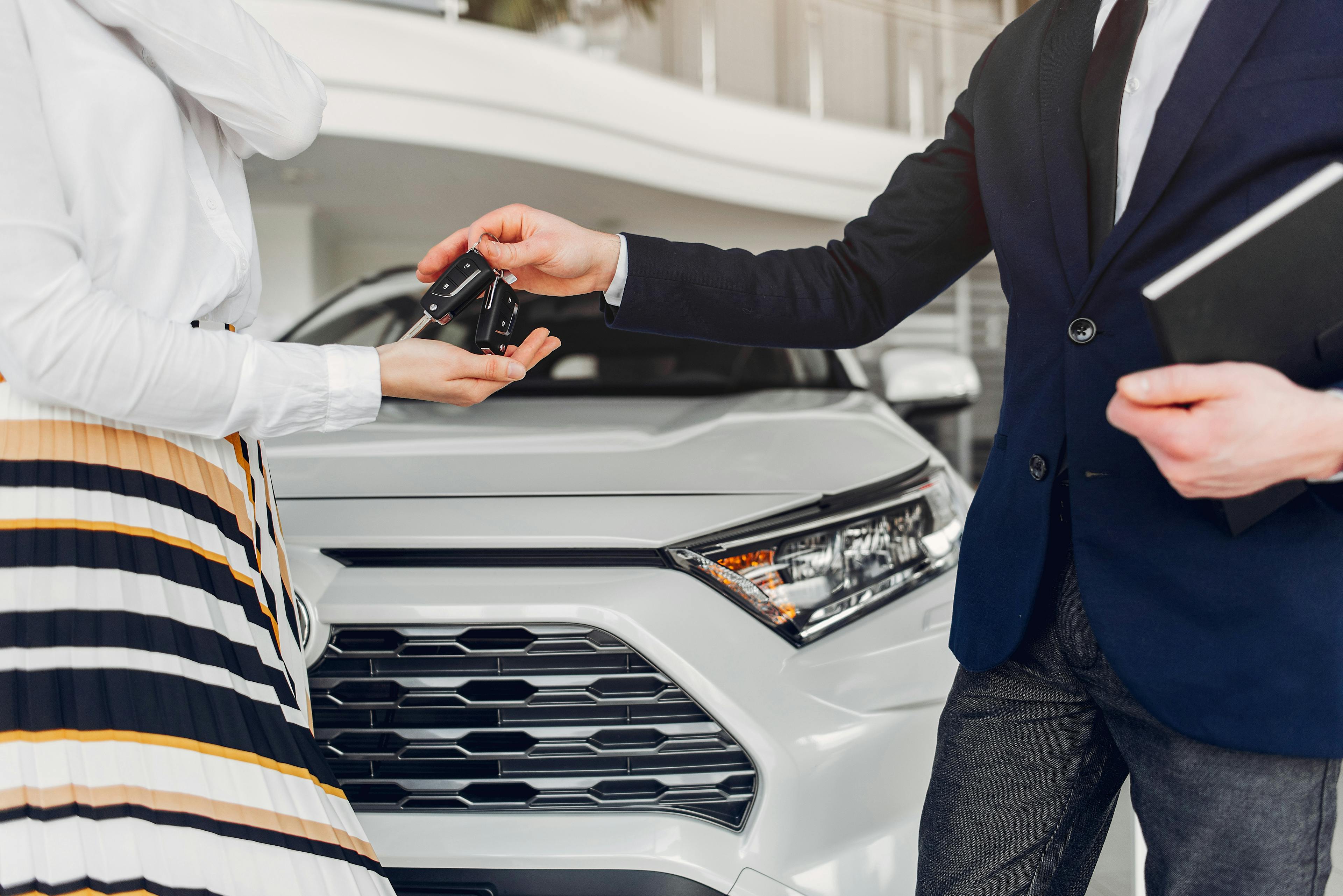 car saleperson handing keys to a client