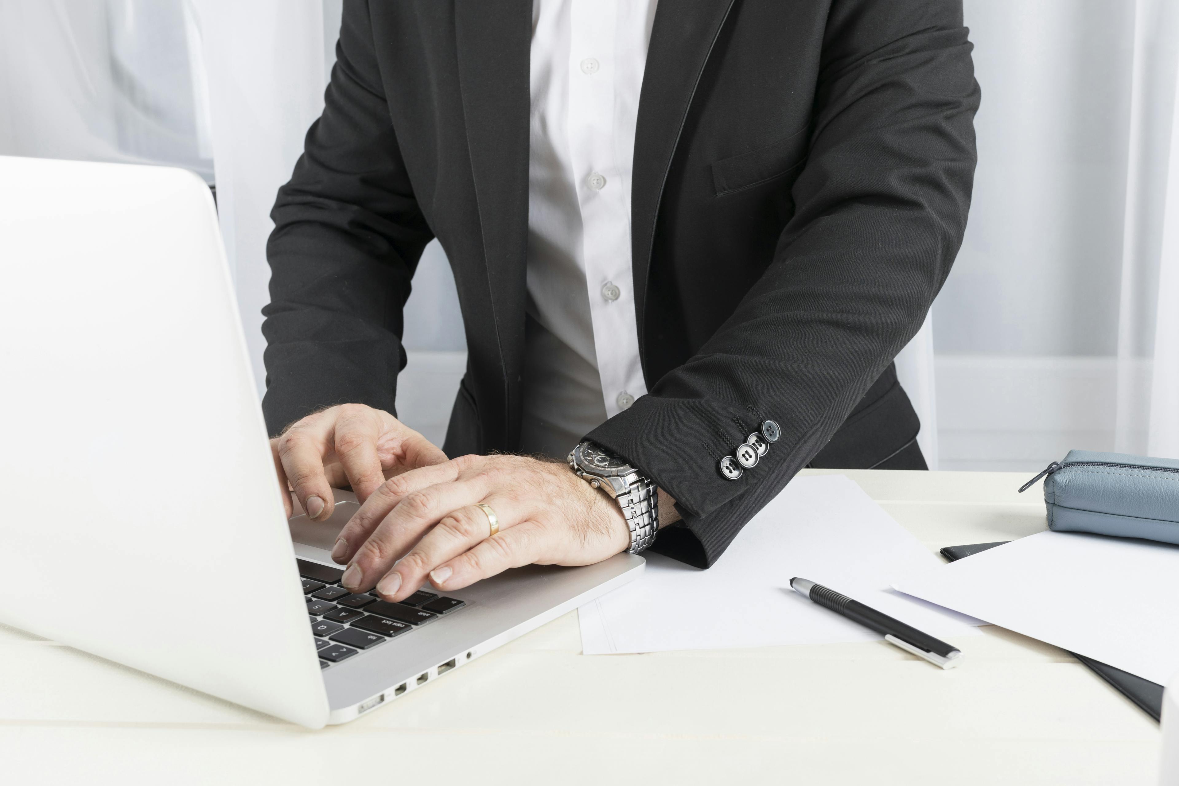man in a suit working on a laptop