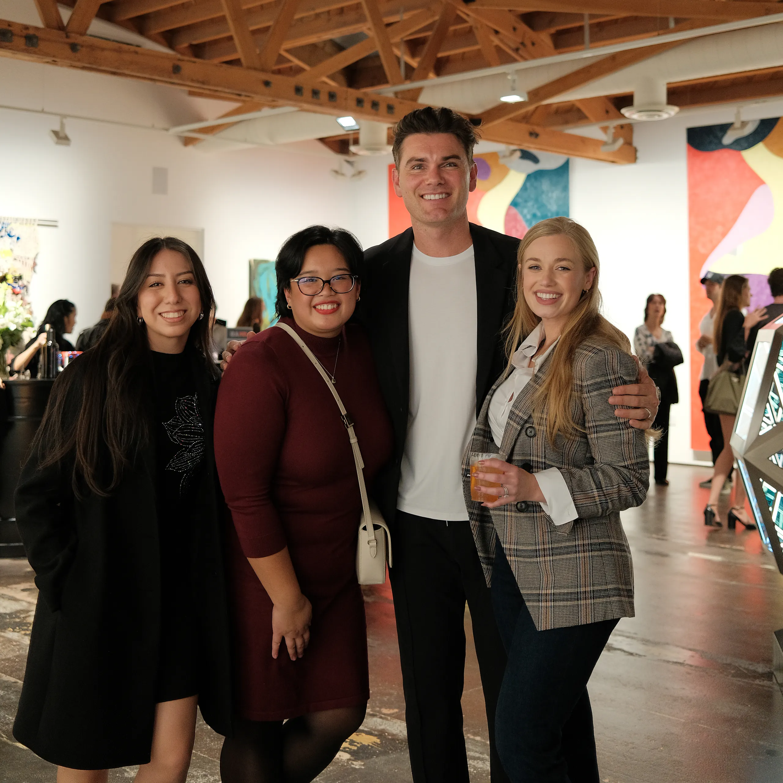 four smiling people in gallery