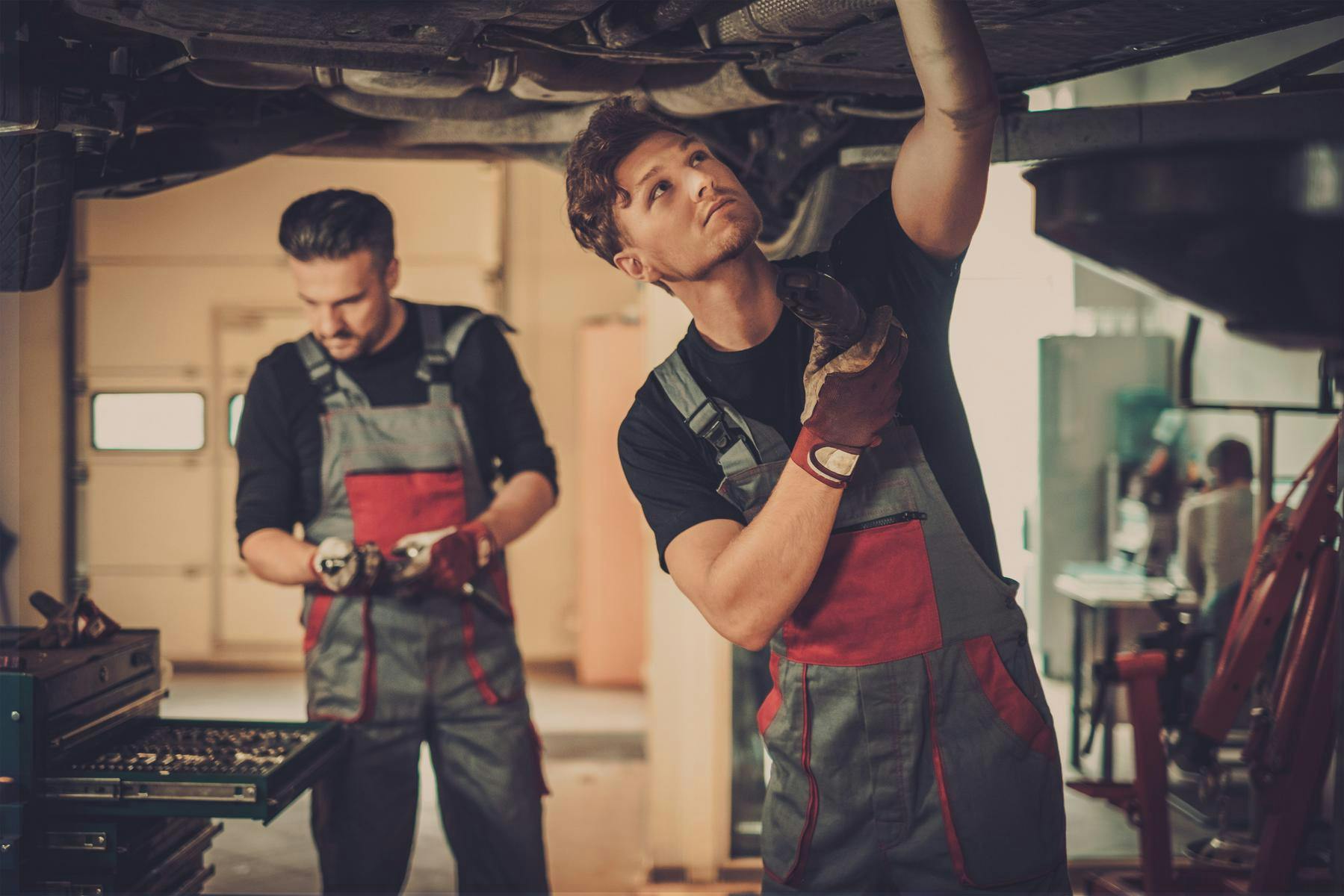 two mechanics working on a car
