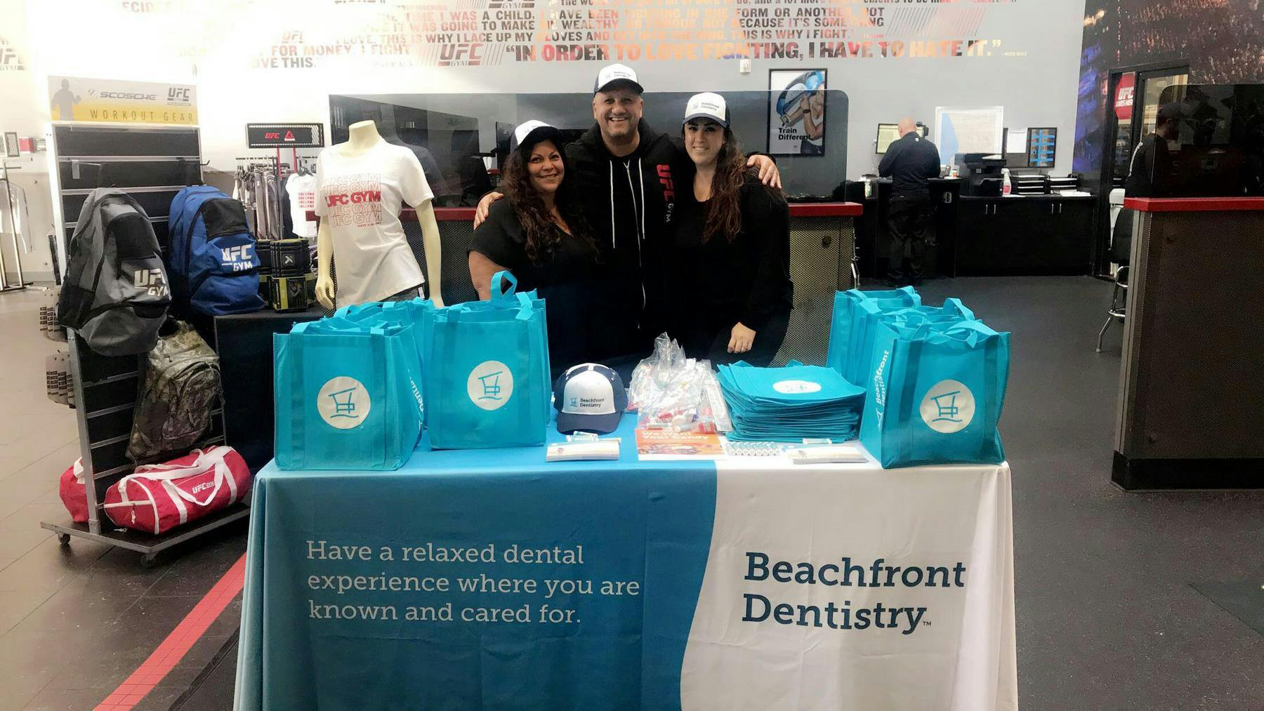 smiling crewmembers in front of merch