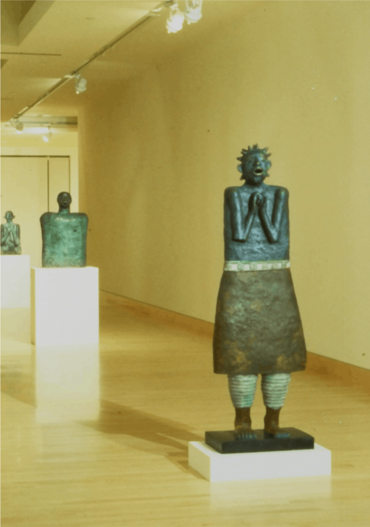 3 pieces - starting at front, Big-eared Torso with Hands on Chest, 1988, bronze, 29x16x5, Black Singer, 1989, bronze, 64x21x13, Torso engraved with Children, 1989, bronze, 34x22x12