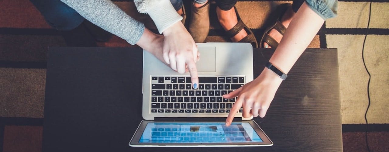 People pointing at laptop screen