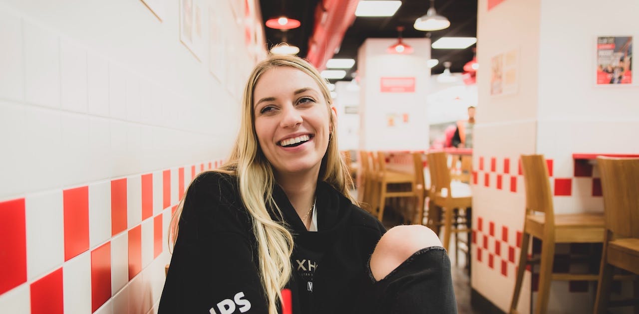 Blonde woman in restaurant smiling happily