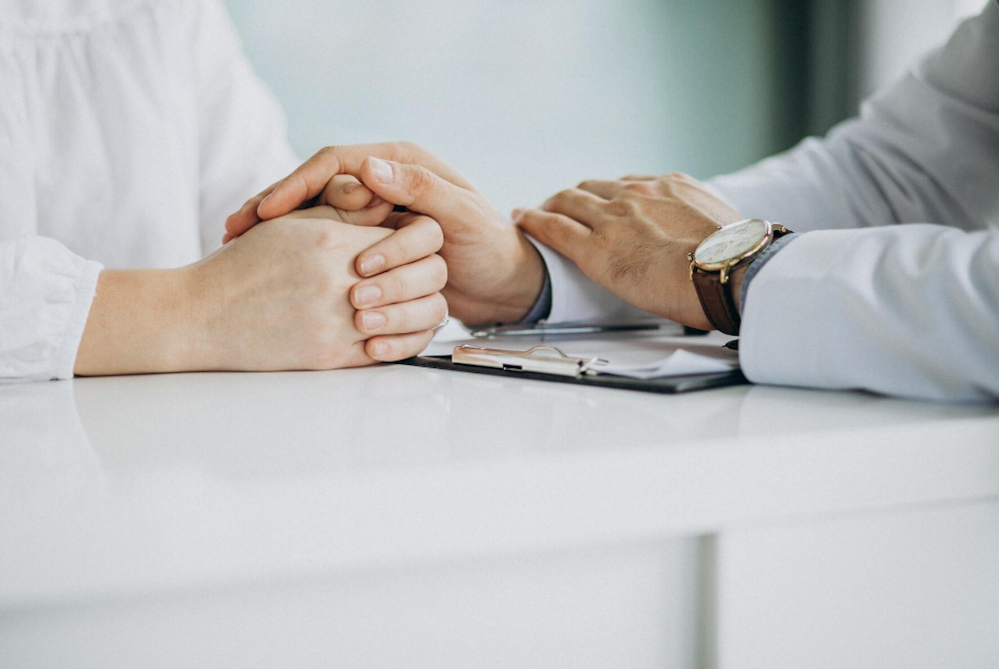 Doctors hand consoling a patients hand