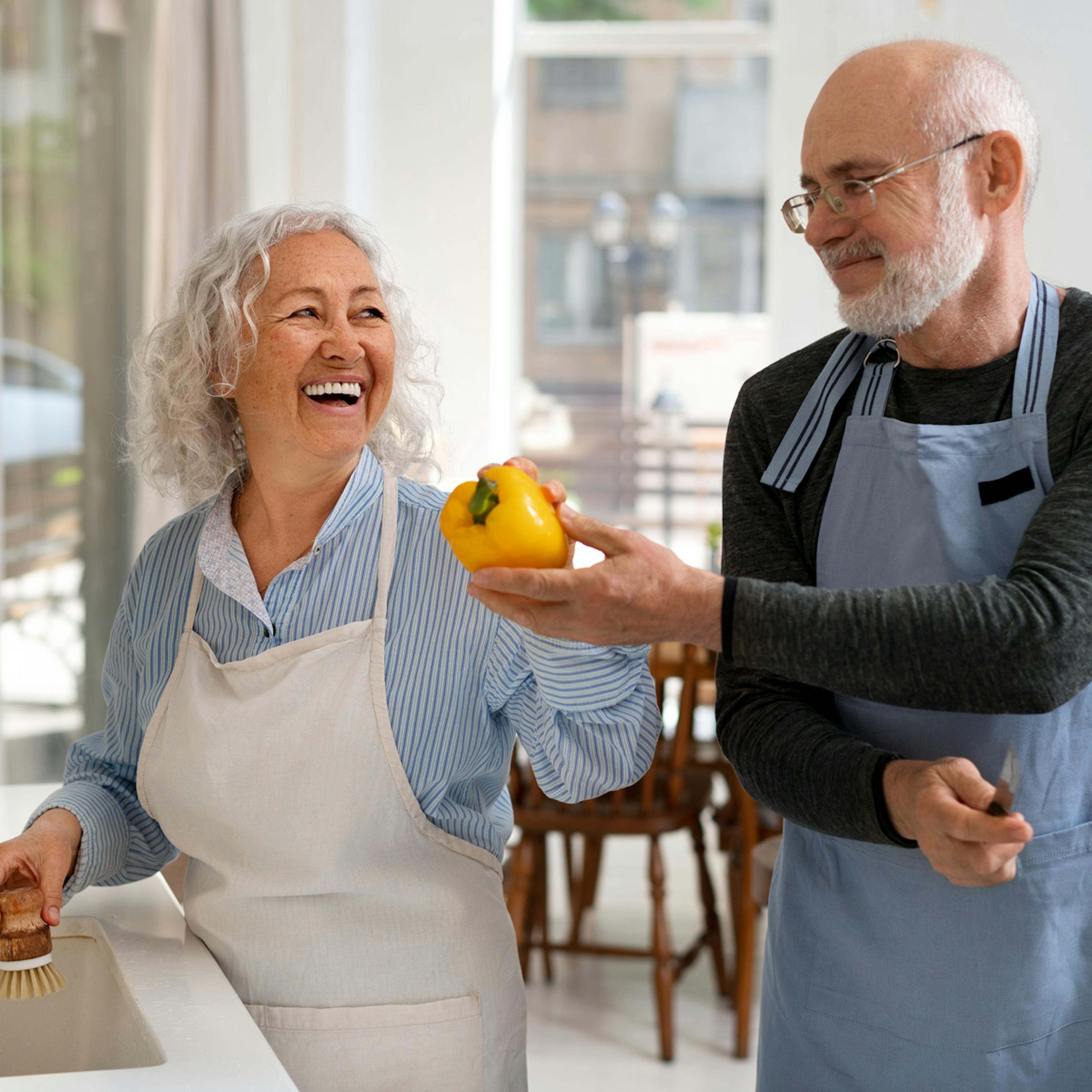 older couple happily preparing food