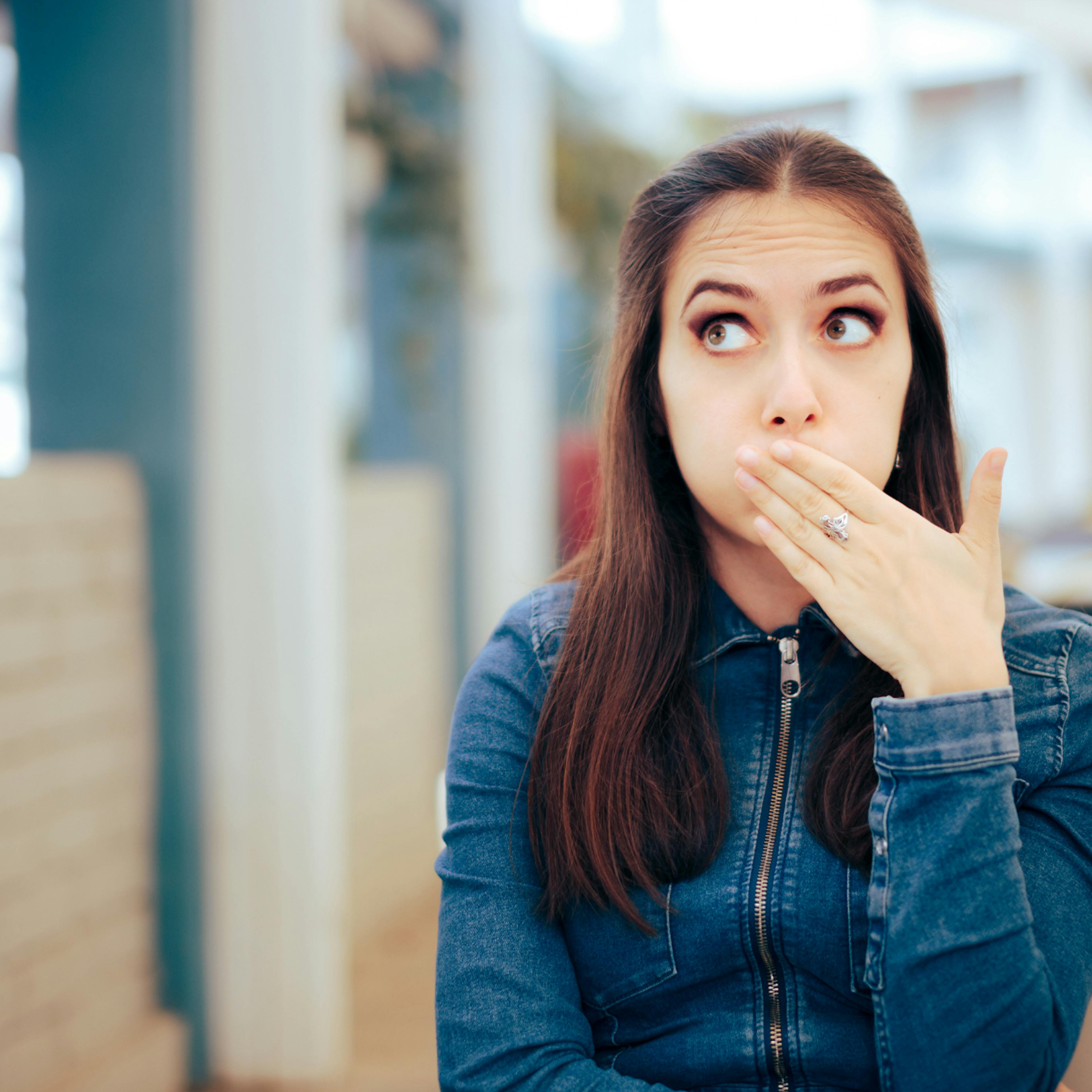 Woman holding her face due to burping 