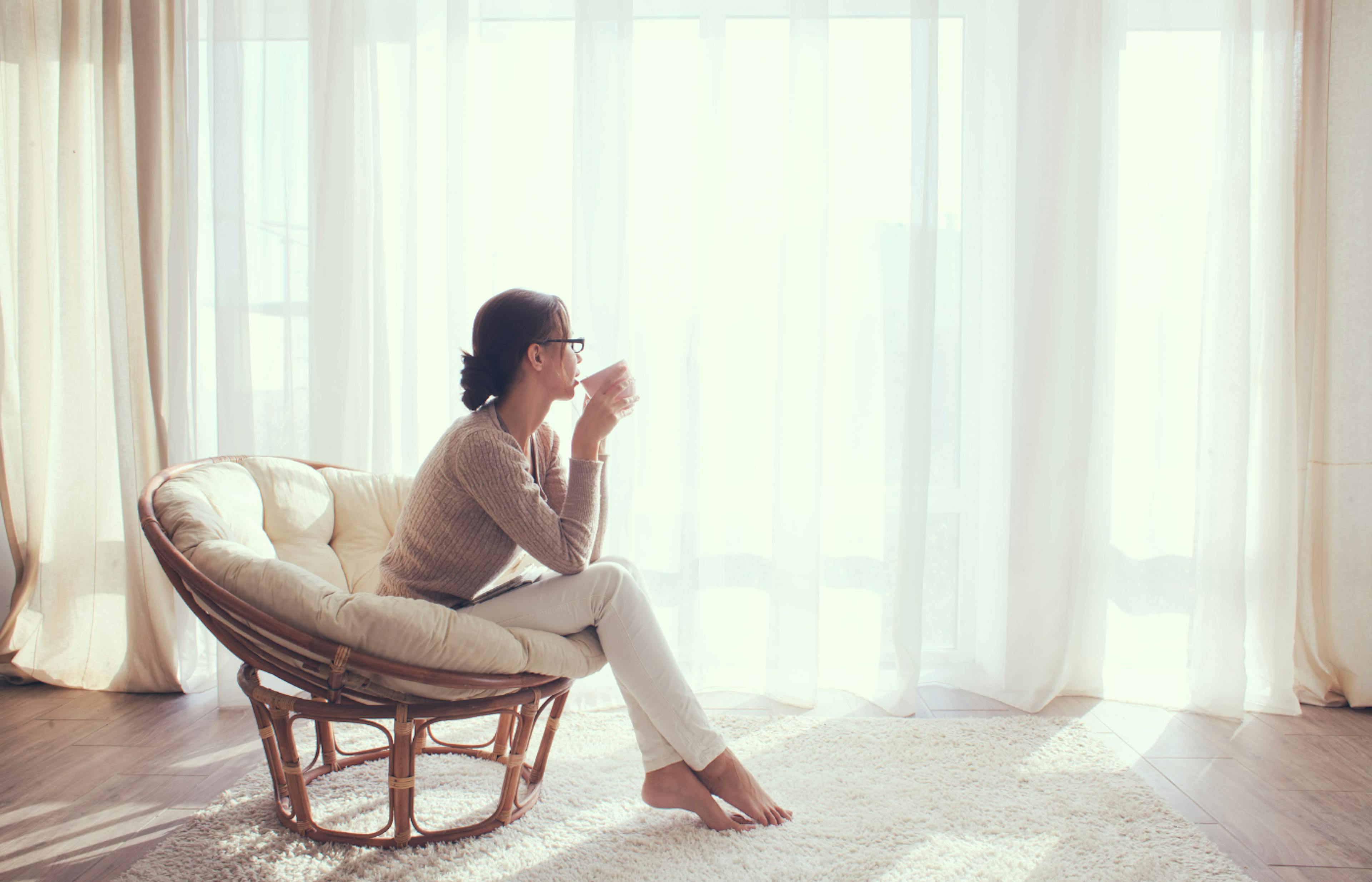 A relaxed woman drinking coffee in her home