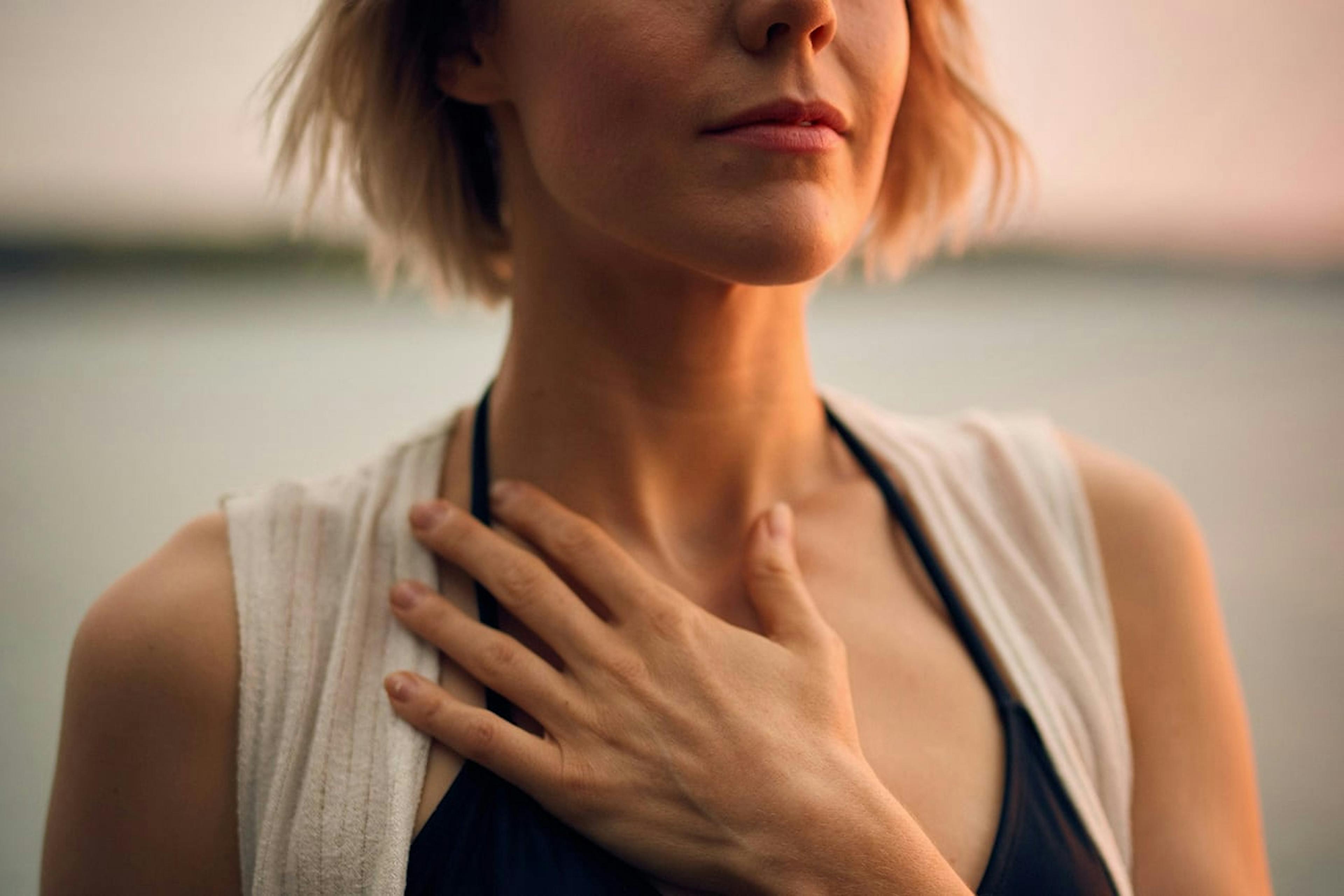 woman holding her throat in pain