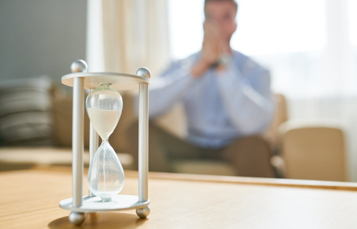 man sitting by a hourglass