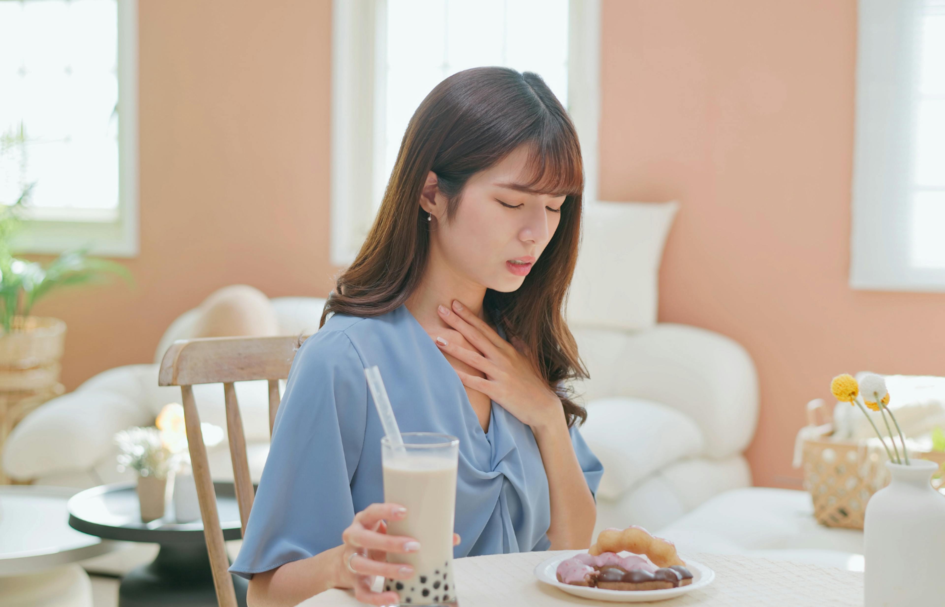 woman holding her throat in pain