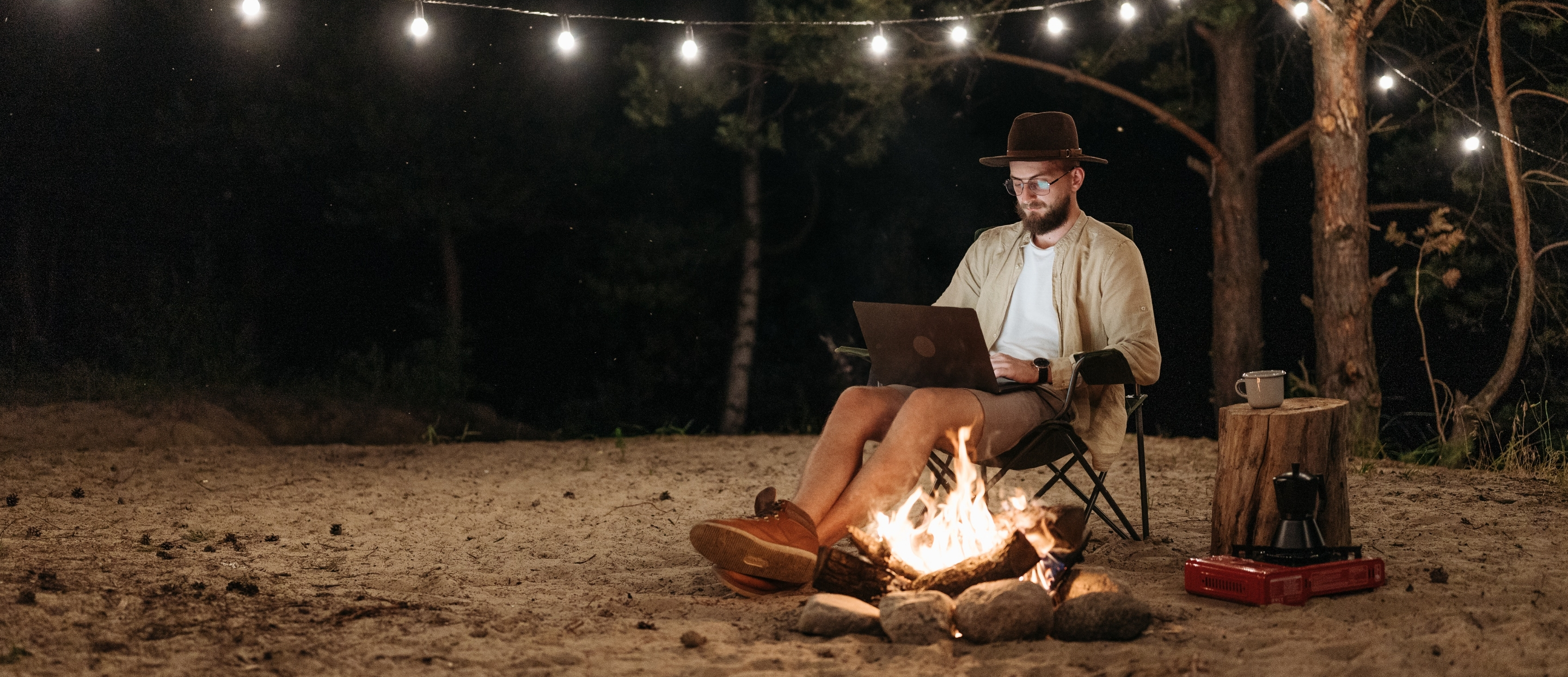 Man by the fire with computer