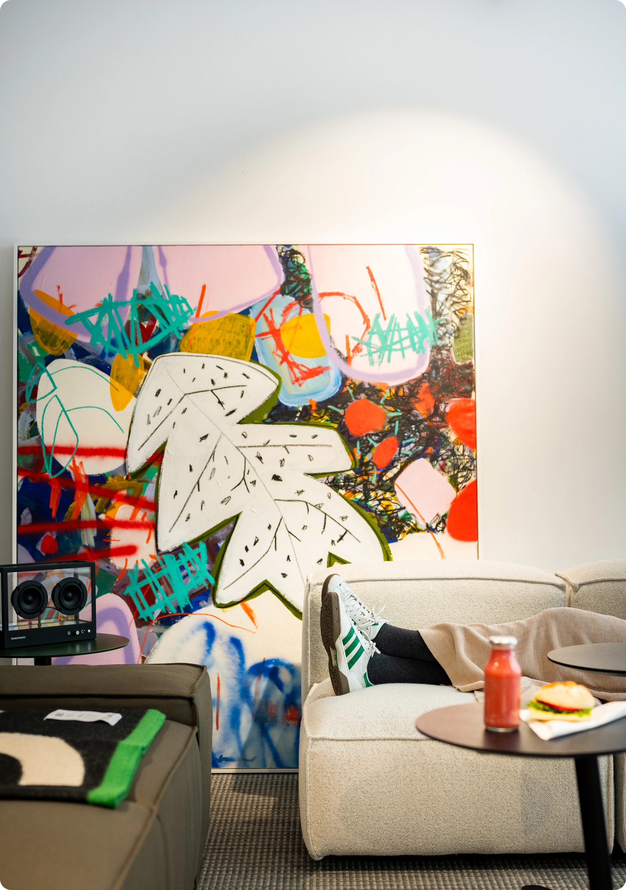 Sofa with a person leaning back. A colorful painting is behind.