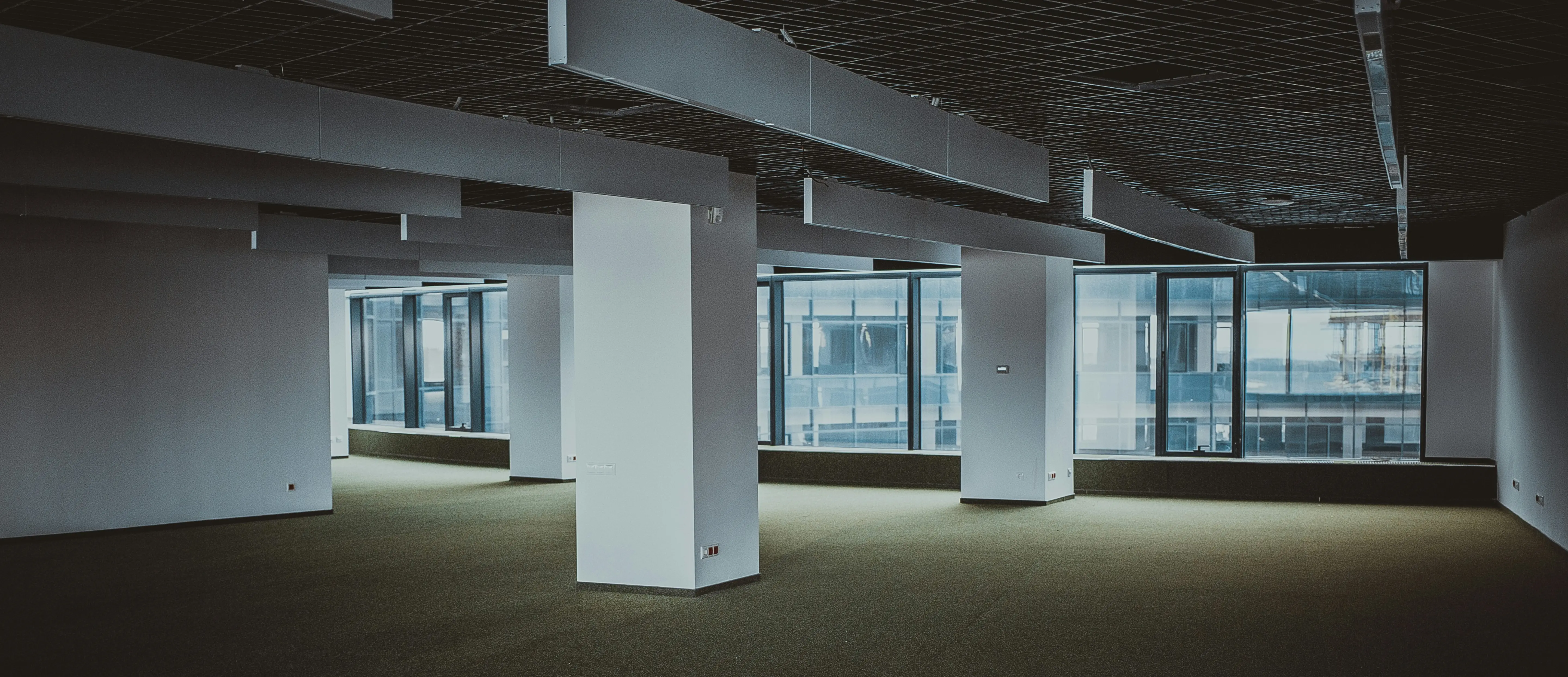 Empty office space with large windows – symbolising rising vacancy rates and the growing need for flexible office solutions.