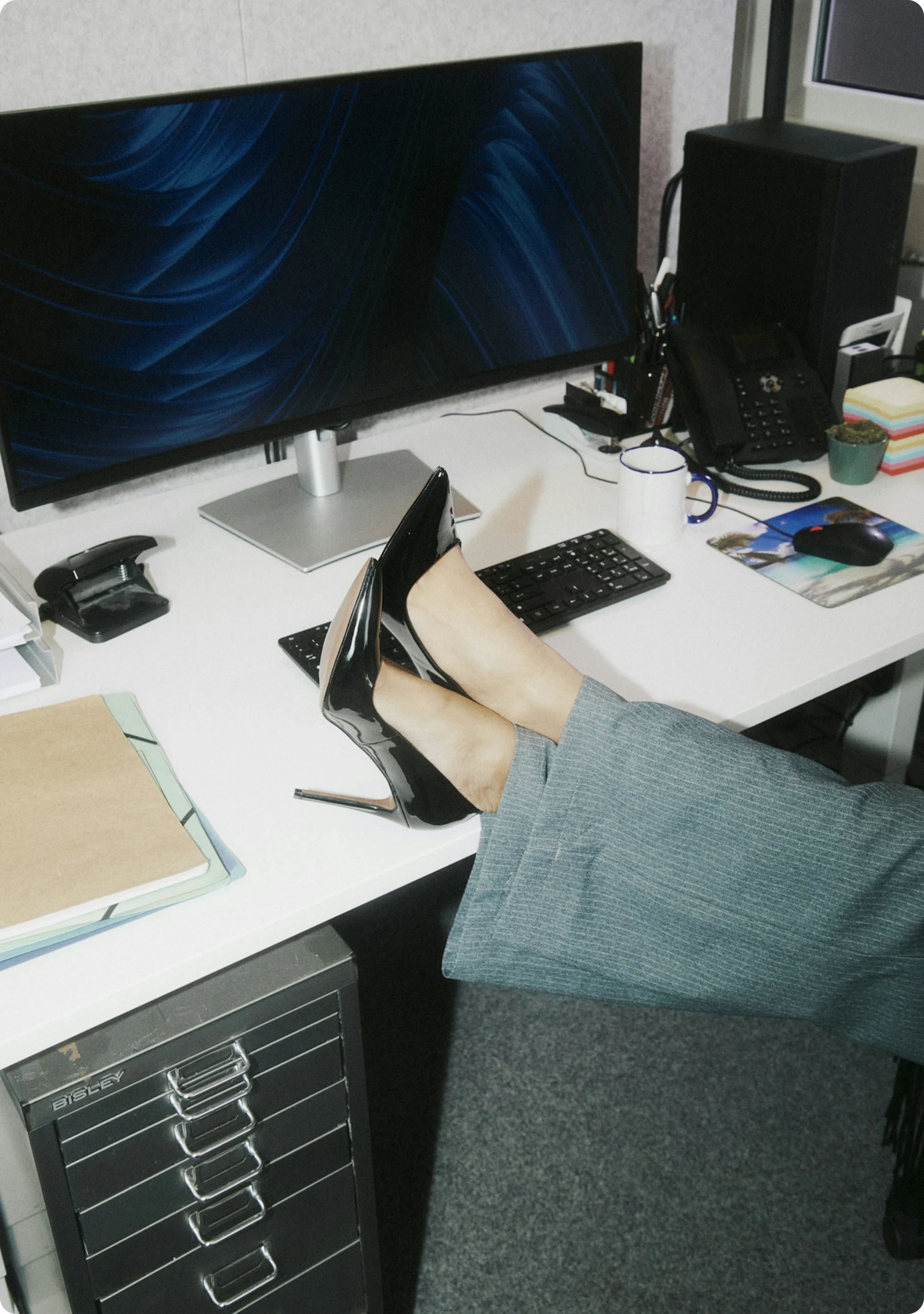 Close-up of an office desk with someone resting their feet on it – symbolizing underused office space and furniture in the era of hybrid work.